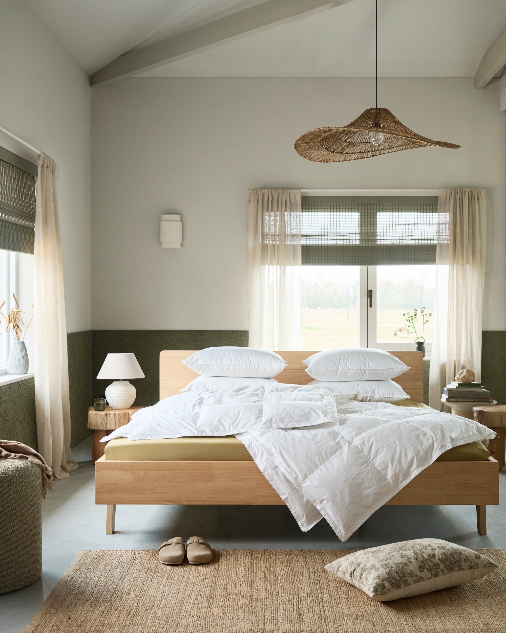 vtwonen dekbed Dixxius Green Royal, gerecycled dons, vanaf € 190,- en vtwonen vierseizoenendekbed Dixxius Green Royal, gerecycled dons, vanaf € 275,- vtwonen hoofdkussen The sustainable one, gerecycled dons, vanaf € 79,95,-.  M.m.v. swisssense.nl (houten ledikant, matrassen), hkliving.com (houten bijzettafels, vloerkleed, bijzettafel), loods5.nl (hoeslakens, hanglamp), zarahome.com (kussensloop, tafellamp, sloffen, plaids, linnen gordijnen, houten bankje). Overig privébezit. vtwonen Landelijk 02-2026 | styling Kim van Rossenberg | fotografie Sjoerd Eickmans | assistentie Rosa van Schie