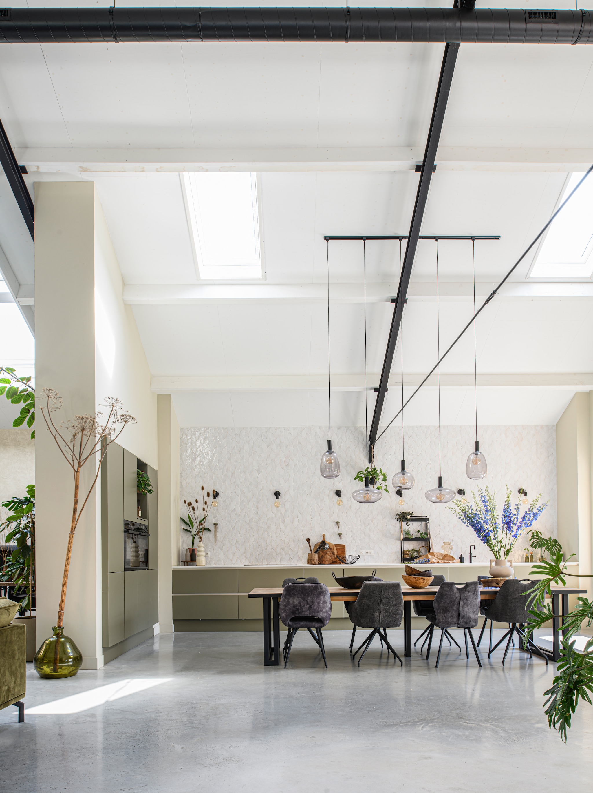 Muurverf Havermout van Gamma. Tegels Platta La Vie van Designtegels. Keuken Graafschap Keukens in de kleur ral 7002. Eettafel zelfgemaakt. Eetkamerstoelen Mx Sofa. Hanglampen Alton van Nordlux. Rek Goudmethout. Vloervaas en vaas op aanrecht Intratuin. Tak geplukt. vtwonen 03-2026 | styling Marit Saladini | fotografie Louis Lemaire | productie Inside Homepage