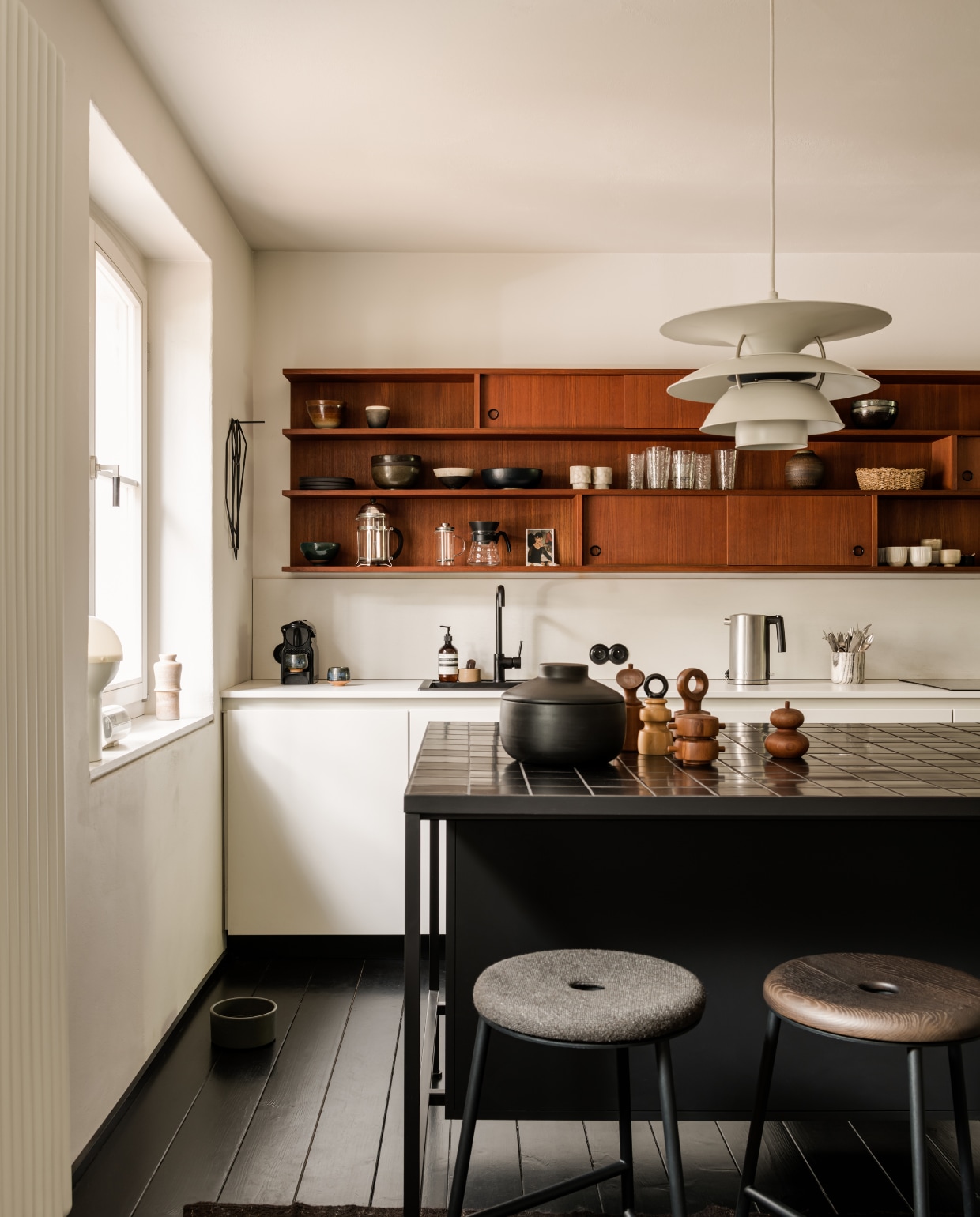 Op het op maat gemaakte eiland staat een collectie vintage teakhouten pepermolens van Jens H. Quistgaard voor Dansk. stijlvol wonen 10-2025 | fotografie oni studio