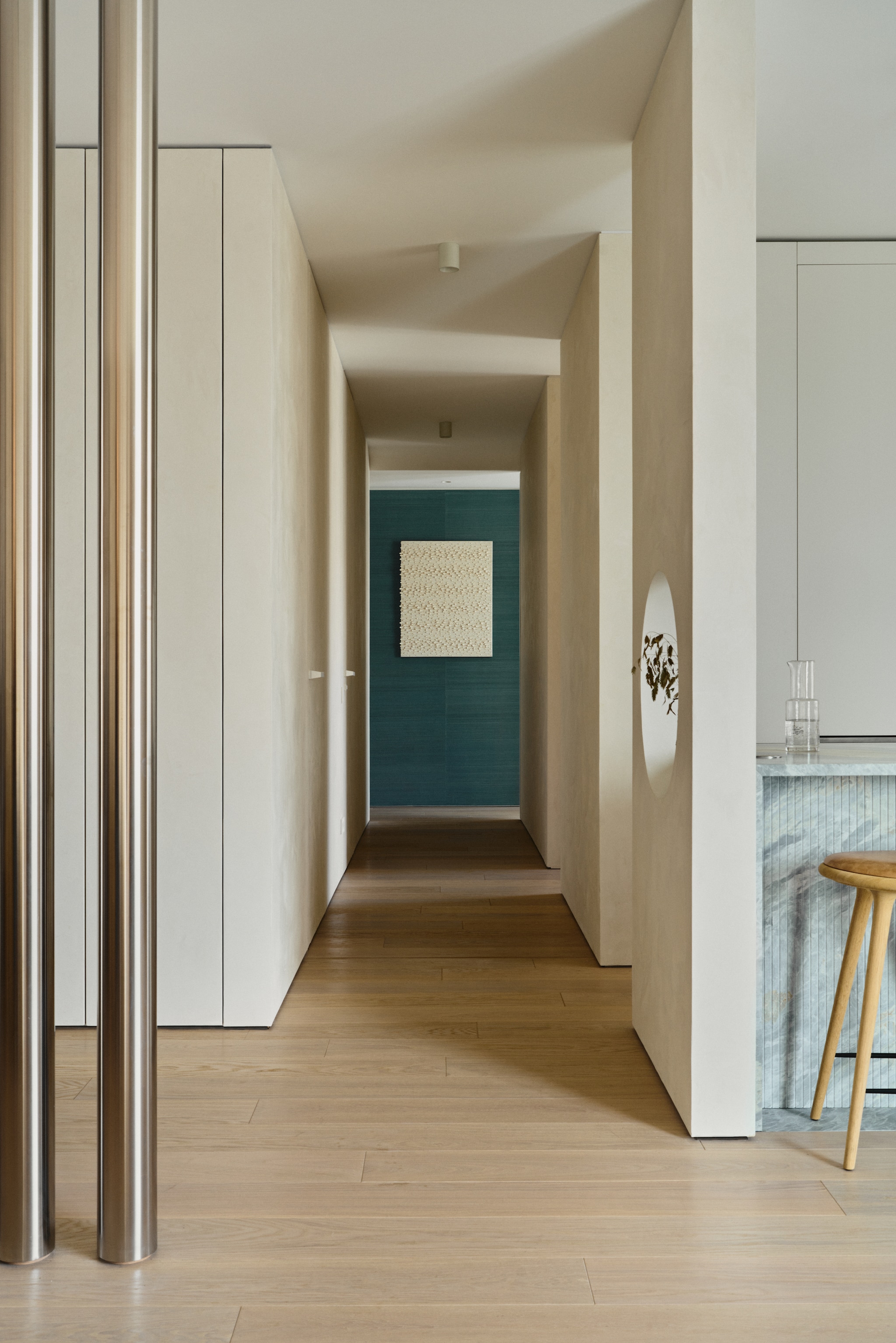 De gang met driedimensionaal schilderij van Jan Buczkowski, dat gedurende de dag verandert afhankelijk van de invalshoek van het licht. vtwonen Design 02-2026 | fotografie Tomo Yarmush | productie Living Inside