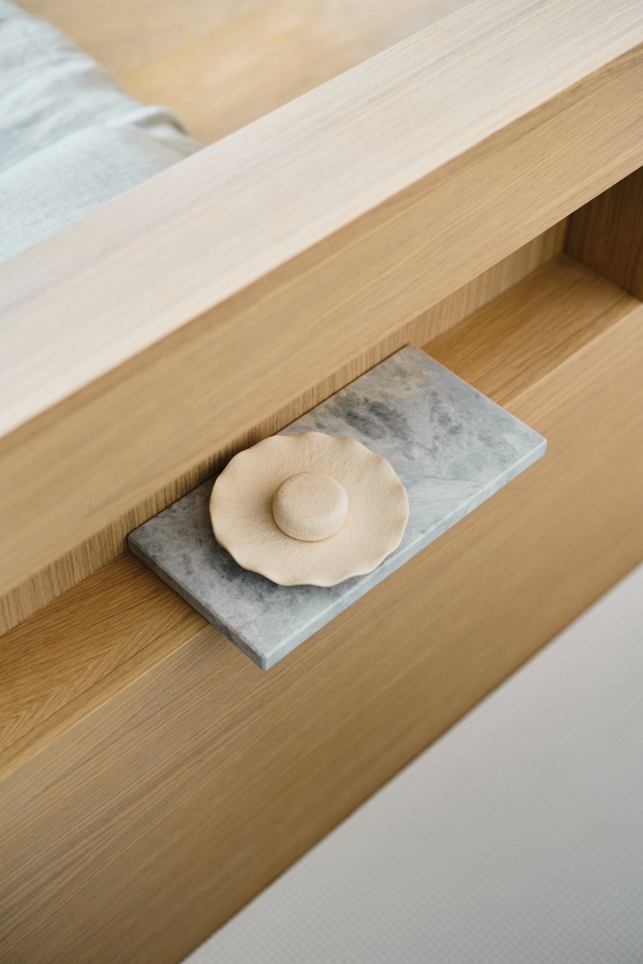 Op maat gemaakte eikenhouten details geven warmte aan de badkamer. vtwonen Design 02-2026 | fotografie Tomo Yarmush | productie Living Inside