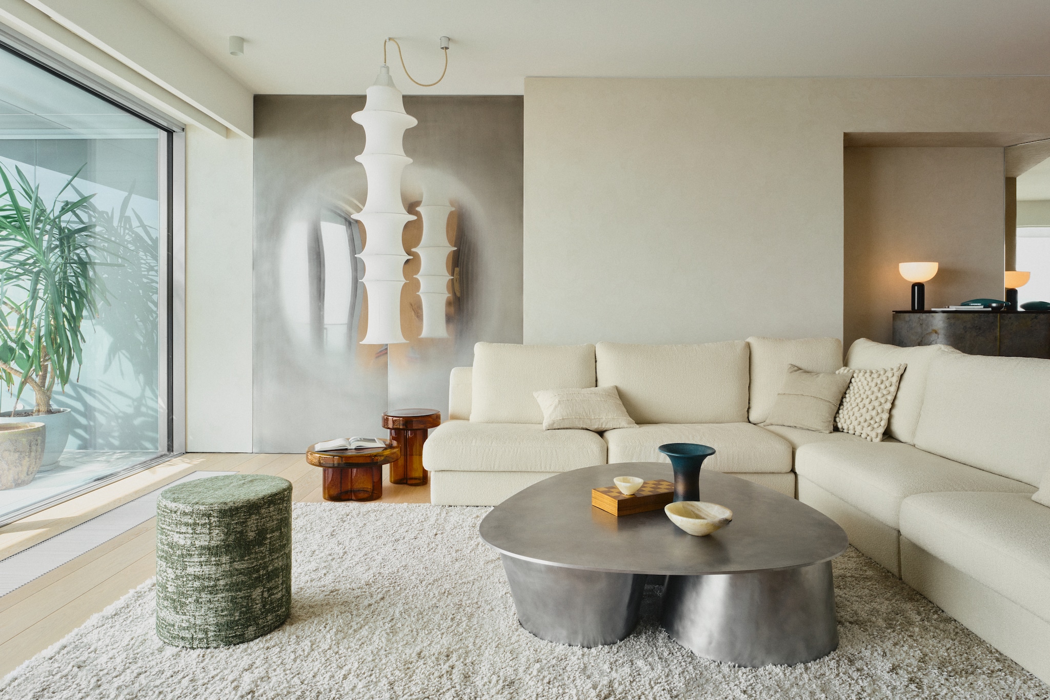 Hoekbank Nobonob. Glazen bijzettafels Miniforms. Hanglampen Bruno Munari. Stalen spiegel Akurat. Aluminium salontafel Jan Ankiersztajn. Vintage schalen. Poef zelf gemaakt. Vloerkleed Roots Living. vtwonen Design 02-2026 | fotografie Tomo Yarmush | productie Living Inside