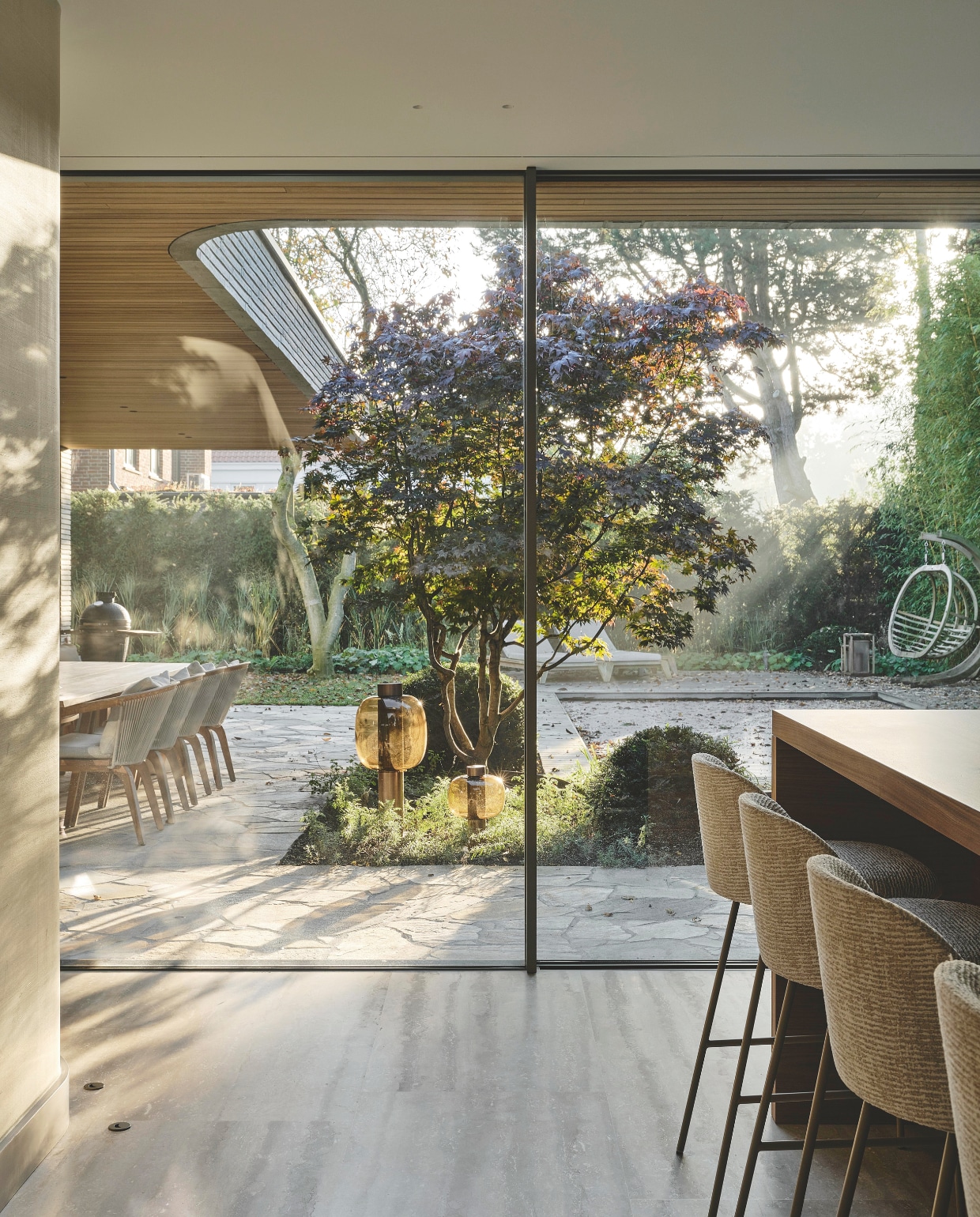 De architecten voegden veel glas toe om de tuin en het interieur in elkaar over te laten lopen en het licht zo lang mogelijk vast te houden. Stijlvol Wonen 10-2025 | fotografie Space Content Studio
