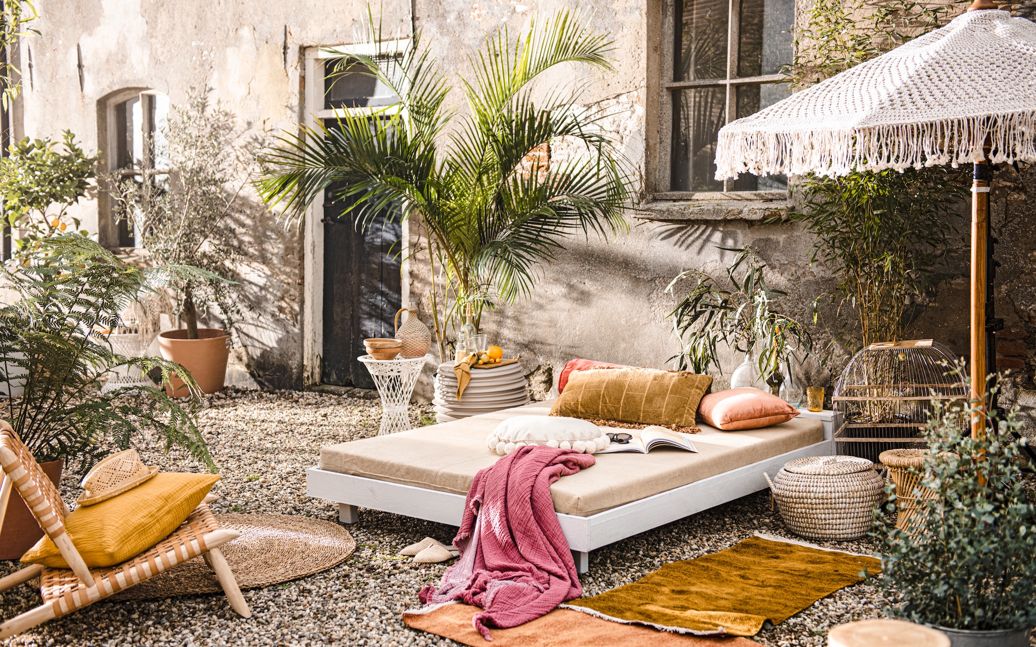 Witte stoel € 298,-, houten stoel met gevlochten leren zitting € 229,-, witte bijzettafel € 219,-, fleskandelaar € 16,95, glas € 6,-, groene keramieken kandelaar € 25,-, glazen karaf € 23,50 (householdhardware.com). Terracottalook potten van Ecopots Amsterdam, per stuk vanaf € 35,99, zeegras vloerkleed van Bloomingville € 94,90 (vtwonen.nl). Keramieken ronde bijzettafel € 800,-, boomstam bijzettafel € 399,- (dacks.nl). Terracotta schalen, per stuk € 7,50, fles met gevlochten buitenkant € 20,-, vaas € 25,-, rotan kruk € 20,- (vandijkenko.nl). Geel marmeren dienblad € 24,95, linnen servet, set van 2 € 7,90 okergeel langwerpig kussen € 69,-, oranje rolkussen € 49,95, roze kussen € 37,-, geel glas € 6,95, mand met deksel € 20,- (loods5.nl). Geel vierkanten kussen € 12,99, plaid € 69,99, rond kussen met pompons € 29,99 (hm.com). Vogelkooi € 75,- (burbri.nl). Handgeknoopte parasol € 595,- (todobien.nl). Planten en bomen (greenlifestylestore.nl). Overig privébezit. vtwonen Tuin Special 02 | Productie Corrien Flohil | Ontwerp en uitvoering Johan Snoodijk | Styling Danielle Verheul | Fotografie Sjoerd Eickmans