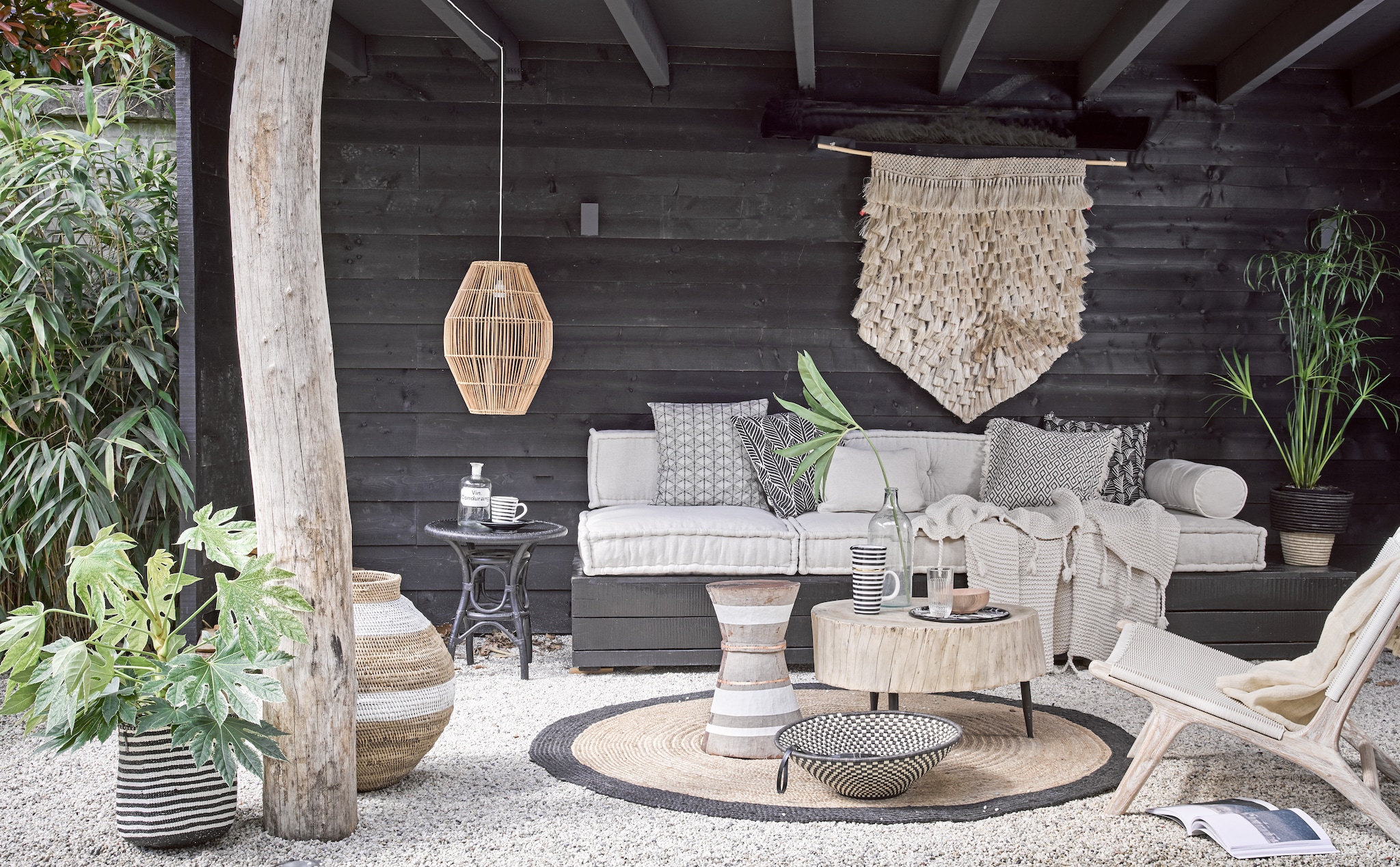 Loungekussens 80x80x15 cm € 195,-, rugkussen 120x30x15 cm € 160,-, rolkussenhoes € 35,-, ecru kussen 50x50 cm € 29,- (Household Hardware). Wandkleed € 295,-, houten buitenstoel € 699,-, hoge gevlochten pot met witte band vanaf € 82,-, houten bijzettafel met witte bies vanaf € 320,-, grote houten tafel € 599,-, lage schaal in zwart-wit € 89,-, hanglamp € 175,-, zwart-wit gestreepte mand vanaf € 47,-, gevlochten pot met zwarte rand € 69,-, ecru plaid Kaldi op stoel € 199,- (Couleur Locale). Gebreide deken € 99,50, vloerkleed rond Ø 180 cm € 175,- (Madam Stoltz). Emaillen dienblad € 27,- (WolfWare). Hoge gestreepte kan € 49,50, gestreepte beker € 15,95 (Maison NL). Houten kom € 9,95 (HK Living). Glas € 6,90 (Six and Sons). Oude apothekersfles € 29,- (De Weldaad). Glazen fles € 30,- (Burbri Antiek). Zwarte bijzettafel € 125,- (All the Luck in the World). Gedessineerde kussenhoes links € 4,99, kussenhoes met zwarte bladeren € 9,99, kussenhoes met rafels en grafisch dessin € 14,99, zwarte kussenhoes met witte blaadjes € 4,99 (H&M Home). vtwonen 08-2017 | styling Cleo Scheulderman | fotografie Alexander van Berge