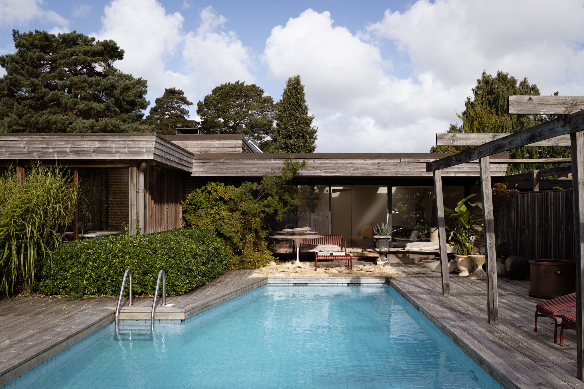 Zwembad uit 1973. Kleed Marie Olsson Nylander. Buitenmeubels Hay. Soortgelijke vaas Eliassen Home & Garden. vtwonen Design 03-2026 | fotografie Monica Spezia | productie Living Inside