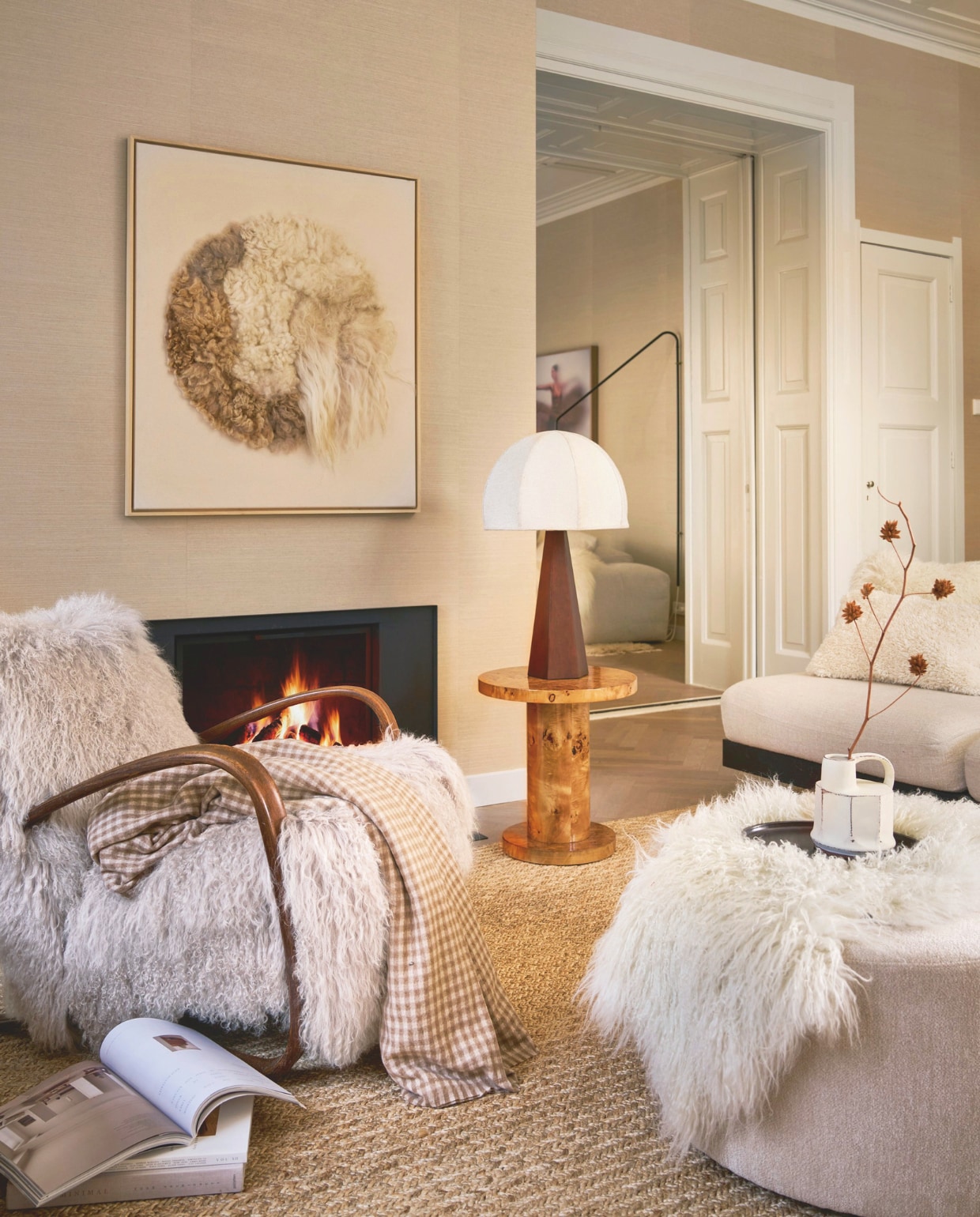 Best Wel Hip fauteuil Jindrich Halabala, vintage, met Tibetaanse schapenvacht, 66x92x77 cm (bxdxh) € 3850,- (bestwelhip.nl). Halona wandobject Moon framed13, Babette Leertouwer, gerecycled wol en katoen, 95x110 cm (lxb) €1495,- (halona.nl). Dutchbone bijzettafel Quinn, bruin, wortelhout fineer met lak, 46x51 cm (Øxh) € 249,-, poef Rocca, beige, polyester, 70x40 cm (Øxh) € 335,- (shop.vtwonen.nl). Dusty Deco tafellamp Hexagon, hout, crème, 30x77 cm (Øxh) € 650,- (dustydeco.com). Serax bank Rudolph van Vincent van Duysen, hout en bouclé, bone, 93x112x72 cm (bxdxh), per element € 3099,- (serax.com). Vachtenspecialist schapenvacht IJslands, op bank, wit € 79,95 (vachtenspecialist.nl). Momo Rugs vloerkleed Naurtex Rope Line, zand, 200x250 cm € 2325,- (vloerkledenwinkel.nl). Zara Home kussenhoes, teddy crème, 40x60 cm € 25,99, deken, beige/bruin geruit, 240x220 cm (lxb) € 59,99, vaas handvat, aardewerk, crème € 19,99, dienblad, donker hout € 17,99 (zarahome.com). vtwonen 12-2025 | styling Cleo Scheulderman | fotografie Jeroen van der Spek