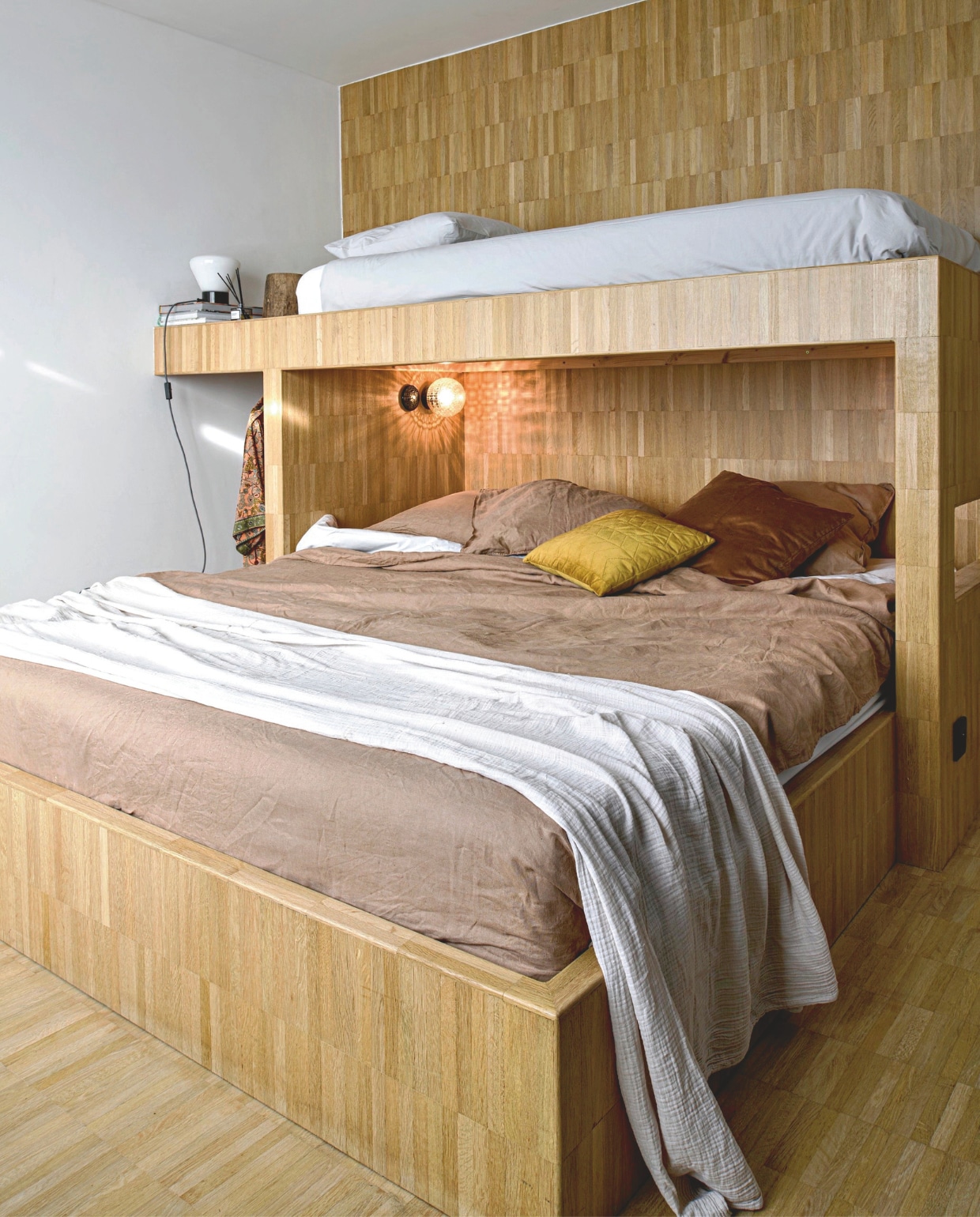 Eikenhouten XL-bed met kinderbed op maat gemaakt door een timmerman. Lampen en sierkussens Zangra. vtwonen 12-2025 | styling Marit Saladini | fotografie Louis Lemaire