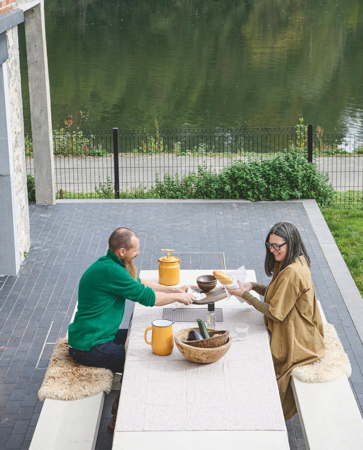 Emaillen servies en schapenvachten Zangra. Tafel en banken Heblad. vtwonen 12-2025 | styling Marit Saladini | fotografie Louis Lemaire