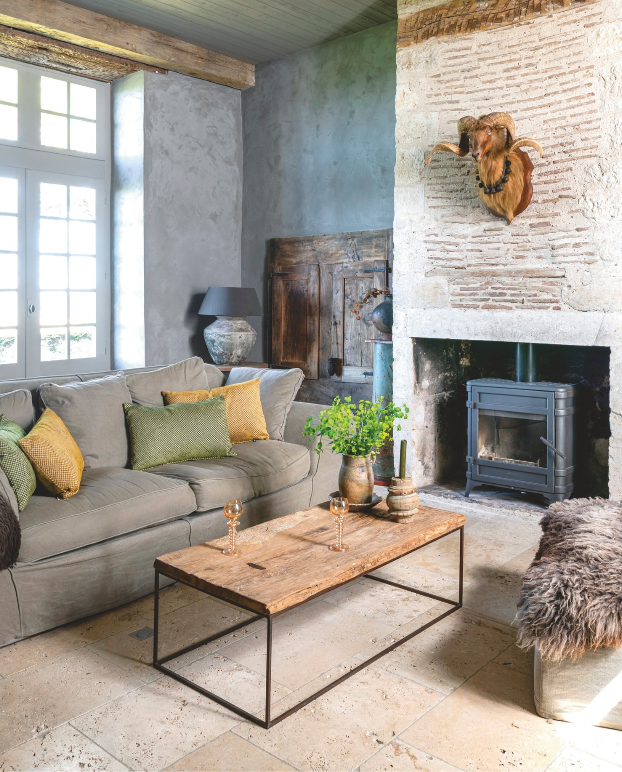 Bank en poef Bocx Interiors. Kussen Hoffz Interior. Plaid, salontafel en glaswerk Cerca Trova.  vtwonen Landelijk 12-2025 | styling Amandine Berthon | fotografie Julien Fernandez