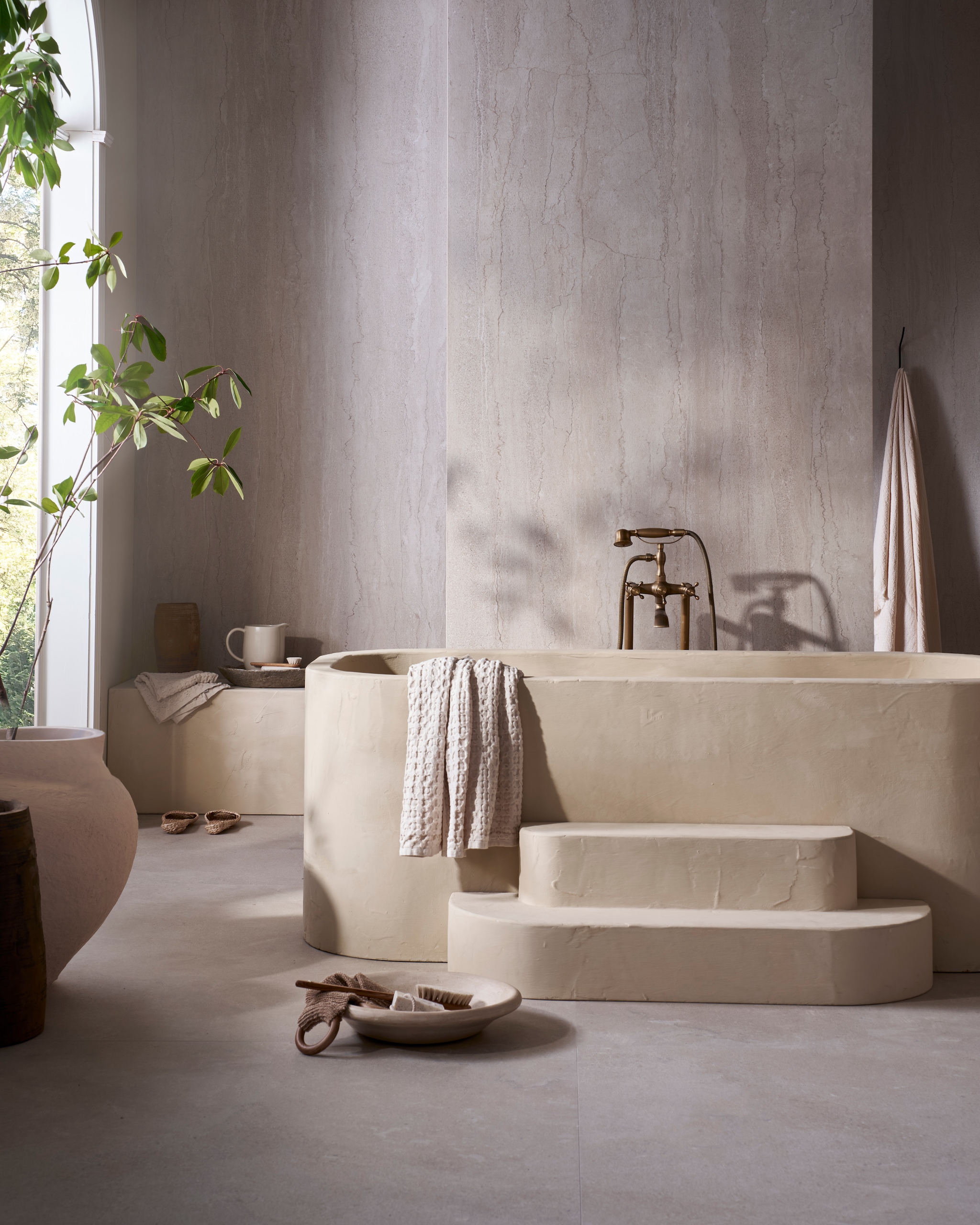 vtwonen tegel Portland Travertine in Marfil 120x280 cm, per m2 € 99,50. weldaad.com (houten pot en vaas), urbannatureculture.com (katoen-maché pot), zarahome.com (handdoeken), householdhardware.nl (schaal van tadelakt). Overig privébezit. vtwonen Landelijk 08-2025 | fotografie Jeroen van der Spek | styling Cleo Scheulderman
