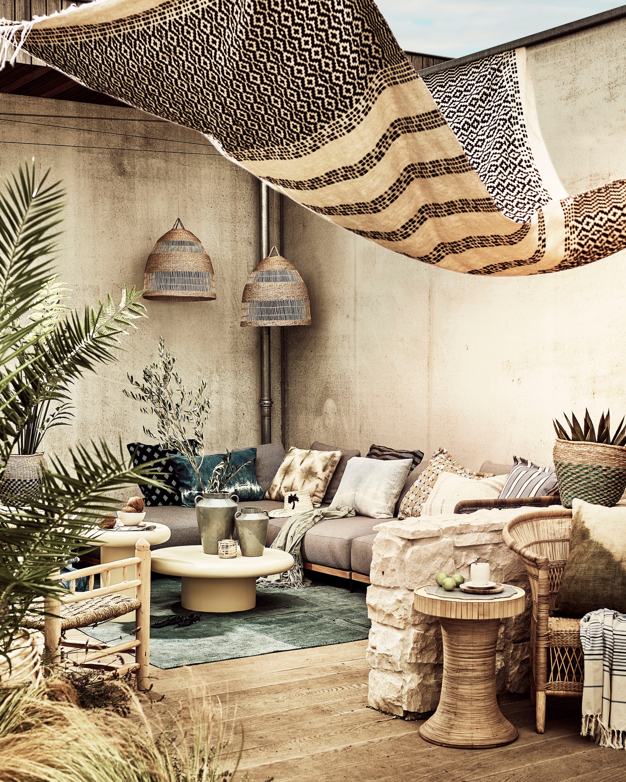 Houten bank, losse elementen, covanderhorst.nl. Blauw vloerkleed, 306x243 cm, stoel rechts, bruin-wit kussen op stoel, wit kussen op bank, lichtblauw kussen, groen-wit tie dye kussen, blauw-wit tie dye kussen, couleurlocale.eu. Deken als zonwering, witte salontafels, laag, hoog, hoed met palm, kop en schotel, houten stoel links, witte kom op hoge salontafel, houten bord onder kom, householdhardware.nl. Ronde houten kruk, maisonnl.com. Gestreepte hamamdoek, glazen waxinelichthouder met gevlochten bekleding, sostrenegrene.com. Geruit servet, set van 2, hoge vaas, lage vaas, groene plaid op bank, zarahome.com. Groene plantenmand, set van 2, blauwe mand, blauw dienblad, sissy-boy.com. Buitenstof kussen geheel links op bank OD 124 45 van Élitis, buitenstof kussen donkerblauw gestreept rechts Lizzo Escala 14, buitenstof kussen bruin met blauwe stippen Sabbia 30482-01 van Rubelli, stof blauw met wit gestreept buitenkussen Dehors Cap Ferrit 002 Avio van Loro Piana, loggerewilpower.com. Planten, plantje.nl. Overig privébezit. vtwonen special 01-2026 | styling Liza Wassenaar | fotografie Sjoerd Eickmans