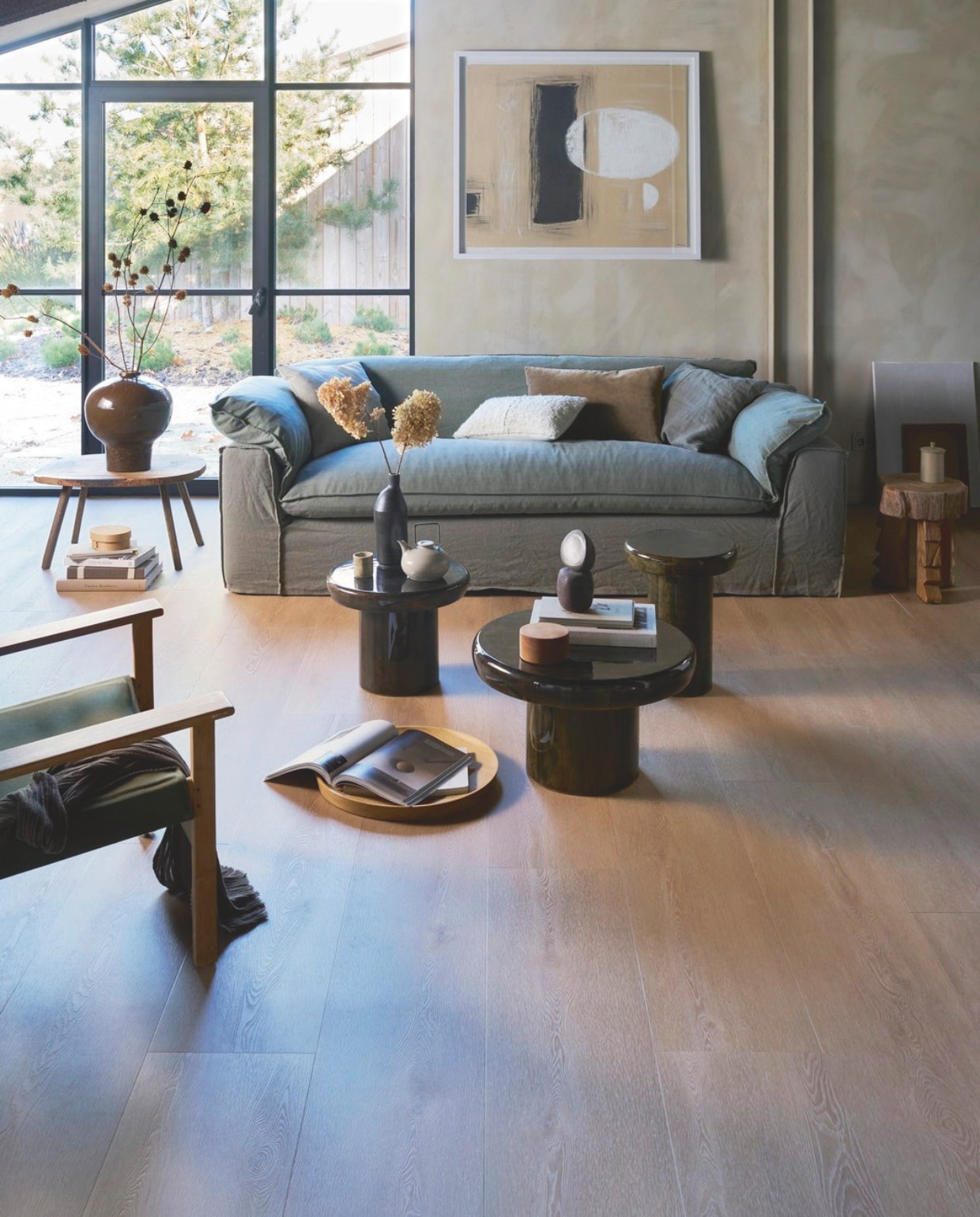 vtwonen pvc-vloer Wide Board, warm natural, 152,5x30,5 cm, dryback per m²  € 44,95, click per m² € 57,95.M.m.v. hkliving.com (bank Nomad, schilderij, fluwelen kussen, ecru kussen, houten bijzettafel Carved, fauteuil Explorer), dutchbone.com (salontafel Mush, bijzettafels Mush), urbannatureculture.com (bruine vaas Ama), marjokedeheer.com (zwarte fles, keramieken object), hethoutlokaal.shop (schaal), @nel_punt (handgedraaide houten doosjes), pietjonker.nl (houten salontafel). Overig privébezit. vtwonen 1-2026 | styling Cleo Scheulderman | fotografie Jeroen van der Spek