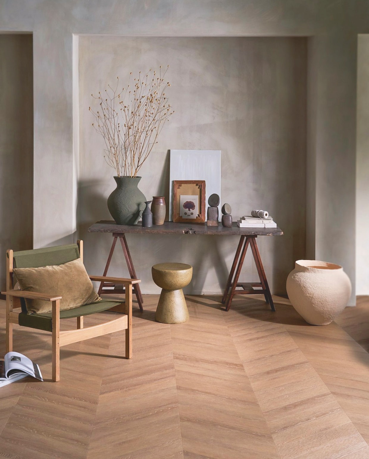 vtwonen pvc-vloer Noble, sunkissed, 53,8x11,7 cm, dryback per m² € 48,95.M.m.v. pietjonker.nl (schragen, tafel, kruk, zwarte kan, bruine pot), urbannatureculture.com (groene vaas, beige pot), hkliving.com (kruk, kussen, fauteuil Explorer). Overig privébezit.