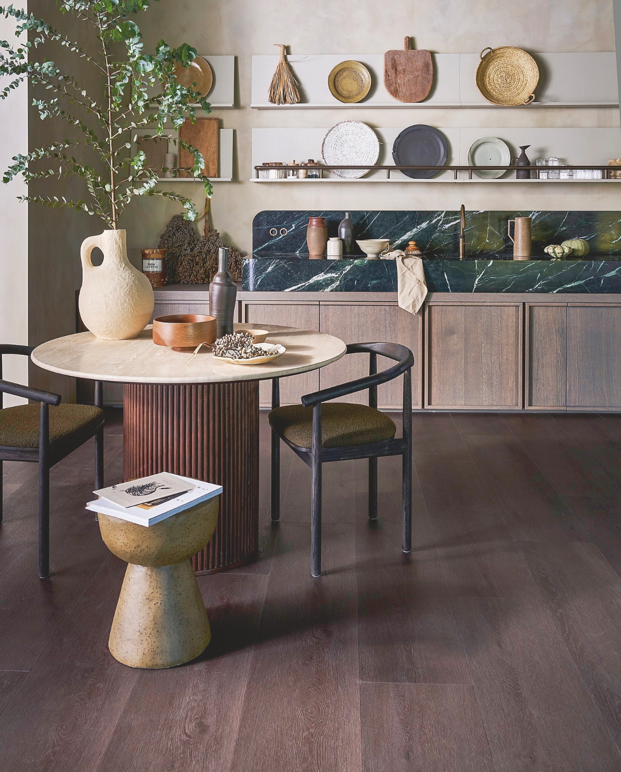 vtwonen pvc-vloer Wide Board, charcoal, 152,5x30,5 cm, dryback per m² € 44,95, click per m² € 57,95.M.m.v. dutchbone.com (eettafel Arda), urbannatureculture.com (witte vaas), marjokedeheer.com (keramieken borden, schalen, flessen), @nel_punt (houten schalen). Overig privébezit. vtwonen 1-2026 | styling Cleo Scheulderman | fotografie Jeroen van der Spek