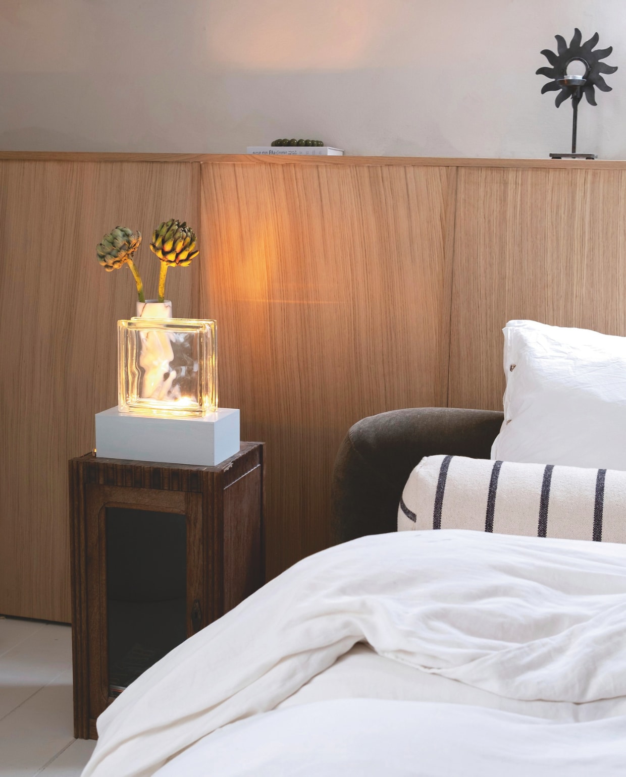 Bed Jotex. Gestreept bolsterkussen zelf gemaakt. Beddengoed Yumeko. Nachtkastje, marmeren vaas en waxinelichthouder tweedehands. vtwonen 01-2026 | styling en fotografie Valerie Paas