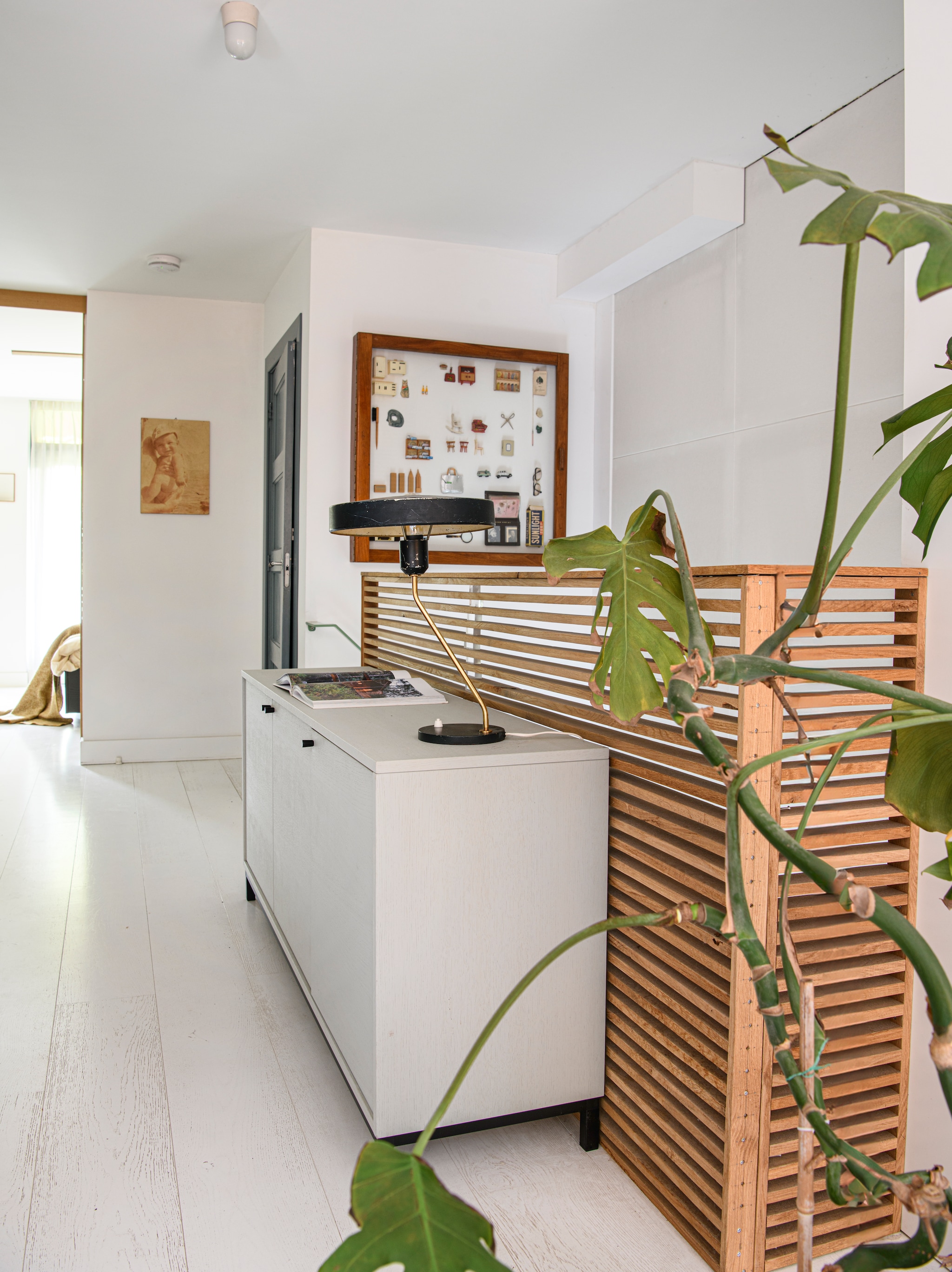 Op de eerste etage doet Stijns lattenwand dienst als balustrade. Lamp vintage. Oude kast uit een school.  vtwonen 04-2026 | styling Kim Timmerman | fotografie Louis Lemaire | productie Insidehomepage