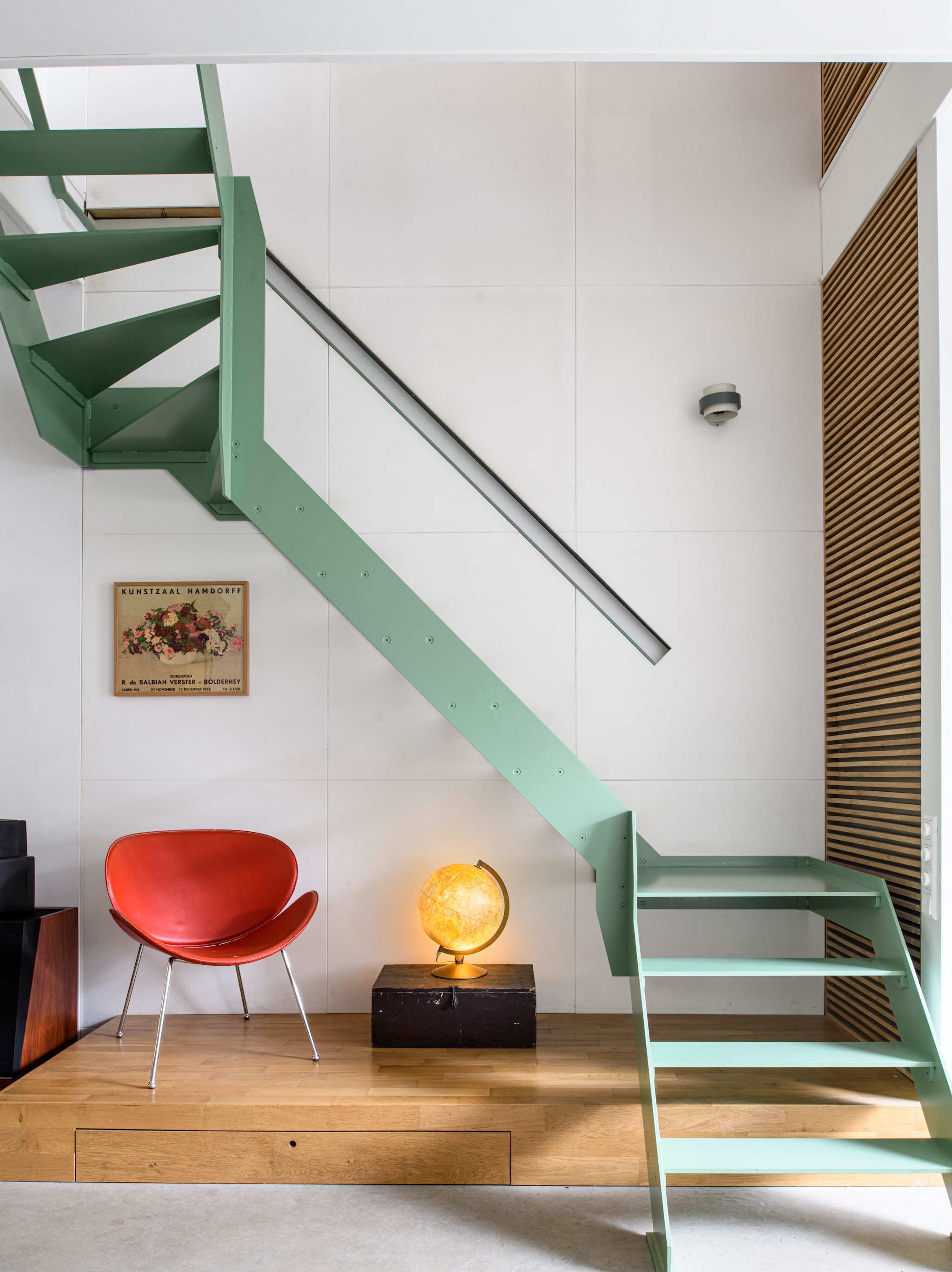 Poster van Klaartjes overgrootmoeder en kunstenares Rie de Balbian Verster. Trap en podium ontwerp en maatwerk Stijn. Stoel uit Denemarken, vintage. vtwonen 04-2026 | styling Kim Timmerman | fotografie Louis Lemaire | productie Insidehomepage