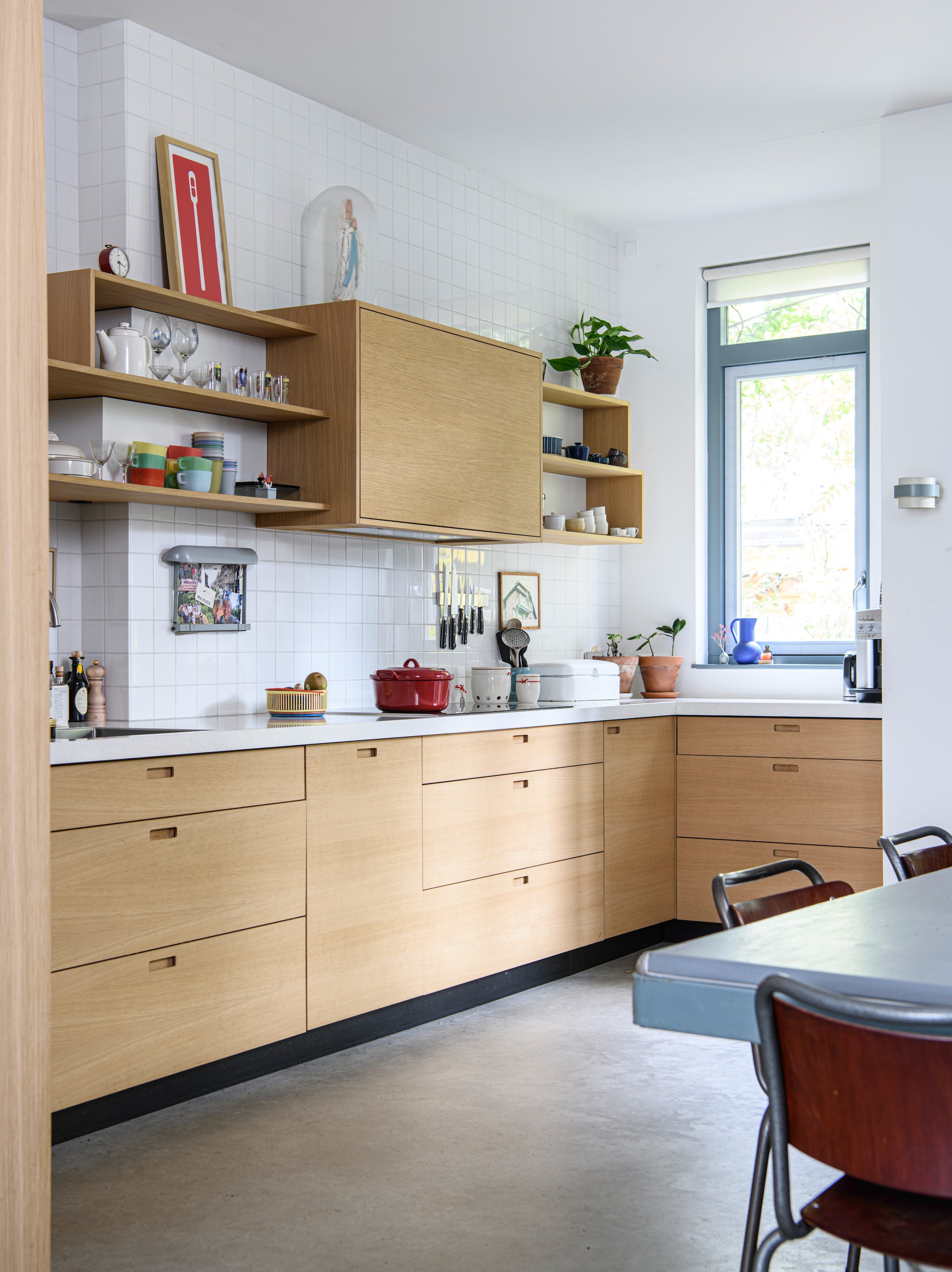 Keuken maatwerk en gerealiseerd door Stijn, fronten van eiken fineer. Tegels Mosa. Zeefdruk Remember Plastic van Paul Wolterink. Stolp met een Mariabeeld erfstuk van Stijns moeder. Wandlamp afkomstig uit een restaurant. vtwonen 04-2026 | styling Kim Timmerman | fotografie Louis Lemaire | productie Insidehomepage