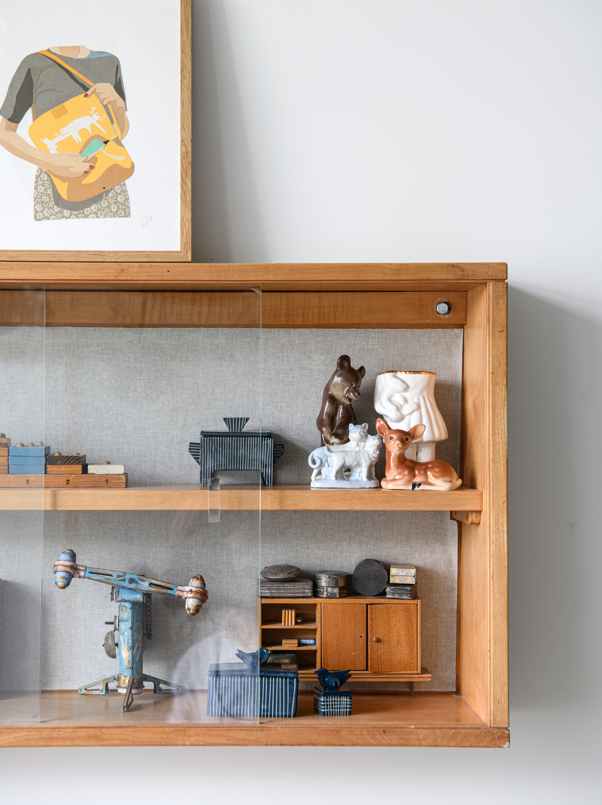 Plafondlamp Dear Ingo van Ron Gilad voor Moooi, tweedehands. Bank Hay. Kussen Manufactum. Oude koelkast omgebouwd tot kast. Bijzettafel oude munitiekist. Wandlamp Jieldé uit Frankrijk. Kunstwerk links Tamasine McNabb. Rotan stoel, vitrinekastje en tafellamp vintage. Klein kunstwerk van Danièle Knirim. Vaas Raawii. vtwonen 04-2026 | styling Kim Timmerman | fotografie Louis Lemaire | productie Insidehomepage