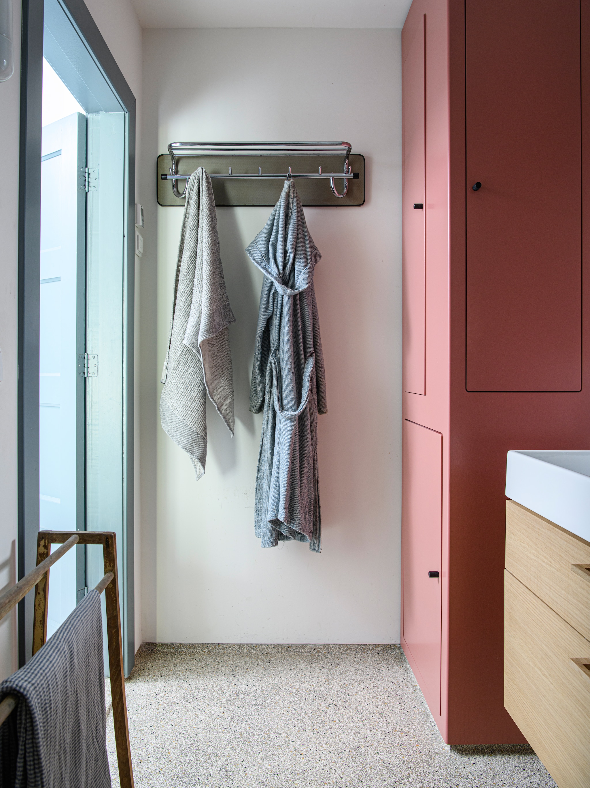 Roze kast maatwerk. Kapstok vintage. Handdoekrek tweedehands. vtwonen 04-2026 | styling Kim Timmerman | fotografie Louis Lemaire | productie Insidehomepage