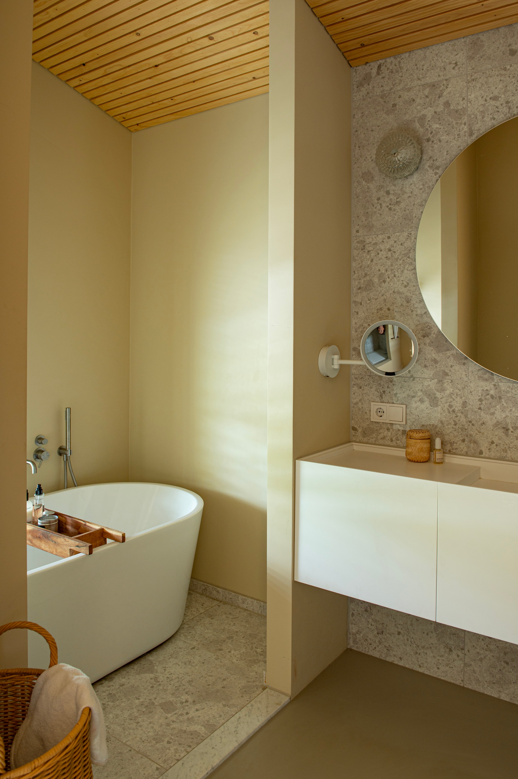 Tegels Ariostea. Badrek Bloomingville. Vergrootspiegel Decor Walther. Badkamermeubel Tiz Design. Wasmand Ferm Living. Vintage wandlamp. Kranen Hotbath. Muurverf Sahara Desert van Pure & Original. vtwonen 04-2026 | styling Jeske Weel | fotografie Caroline Coehorst