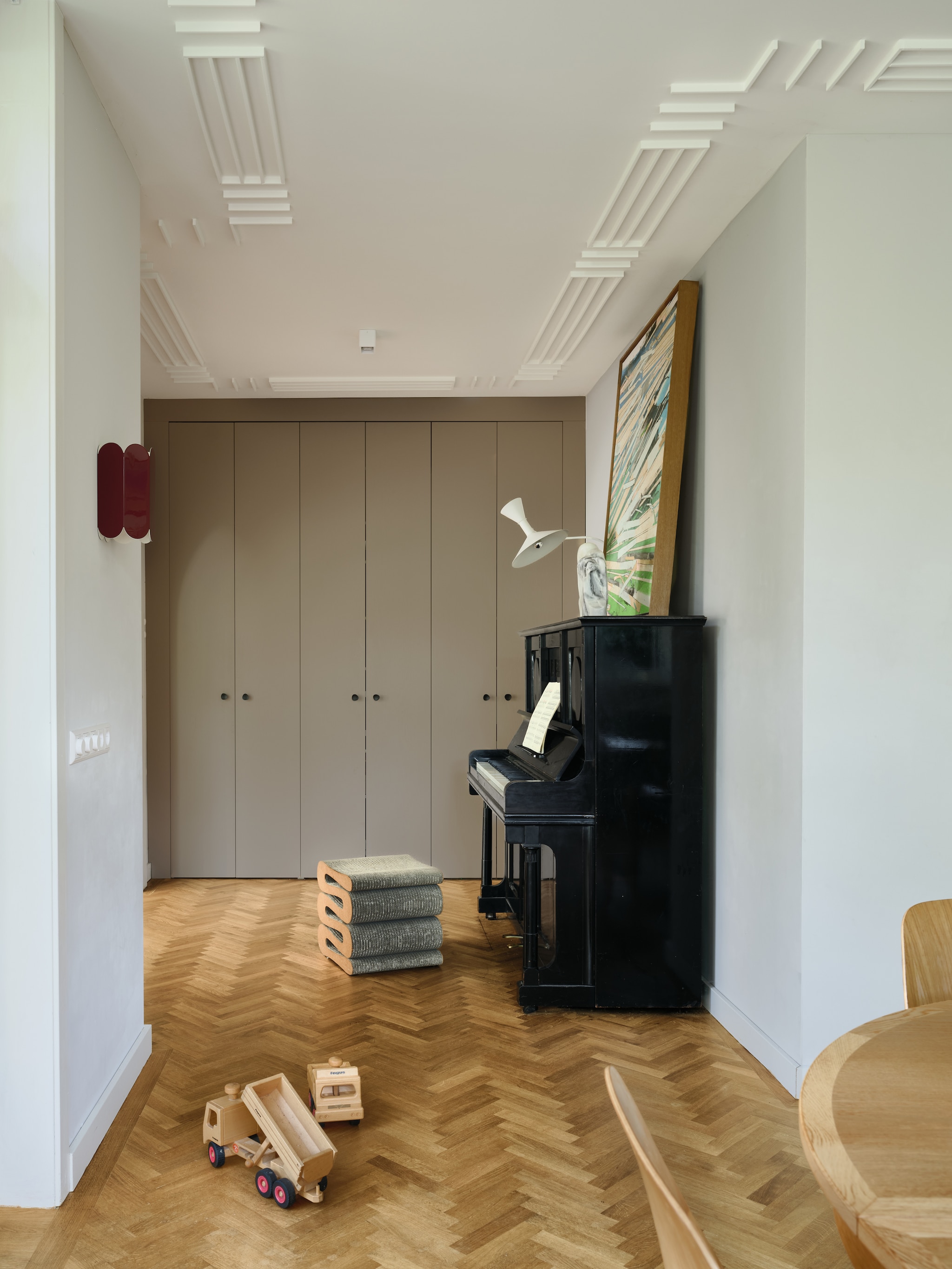 Ingebouwkast op maat. Schilderij van Erik de Bree. Lamp boven piano Marseille van Le Corbusier voor Nemo Lighting. Kruk Wiggle van Frank Gehry voor Vitra. Muurlamp Arcs van Muller Van Severen voor Hay. Piano uit ongeveer 1900. vtwonen 04-2026 | fotografie Mr. Frank