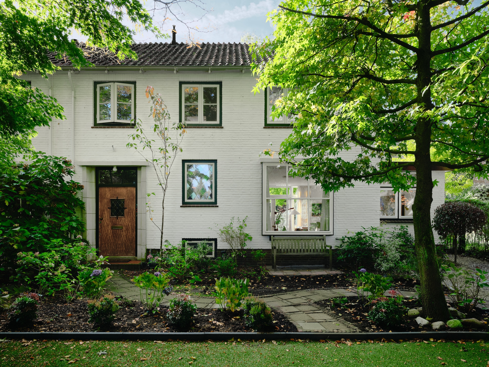 De bakstenen gevel is sober. Bij het vernieuwen van de ramen met dubbelglas lieten ze de oorspronkelijke stolppramen boven namaken. vtwonen 04-2026 | fotografie Mr. Frank