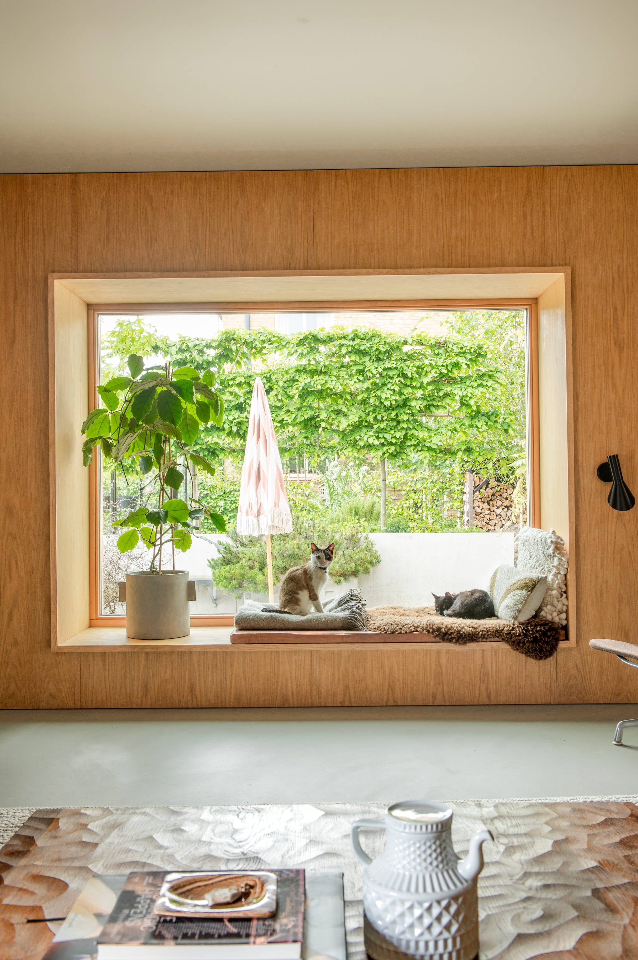 Theepot Sargadelos. Wandlamp AJ Arne Jacobsen voor Louis Poulsen. Bloempot en parasol Bynord. Kussen vensterbank op maat gemaakt. vtwonen 04-2026 | styling Jeske Weel | fotografie Caroline Coehorst