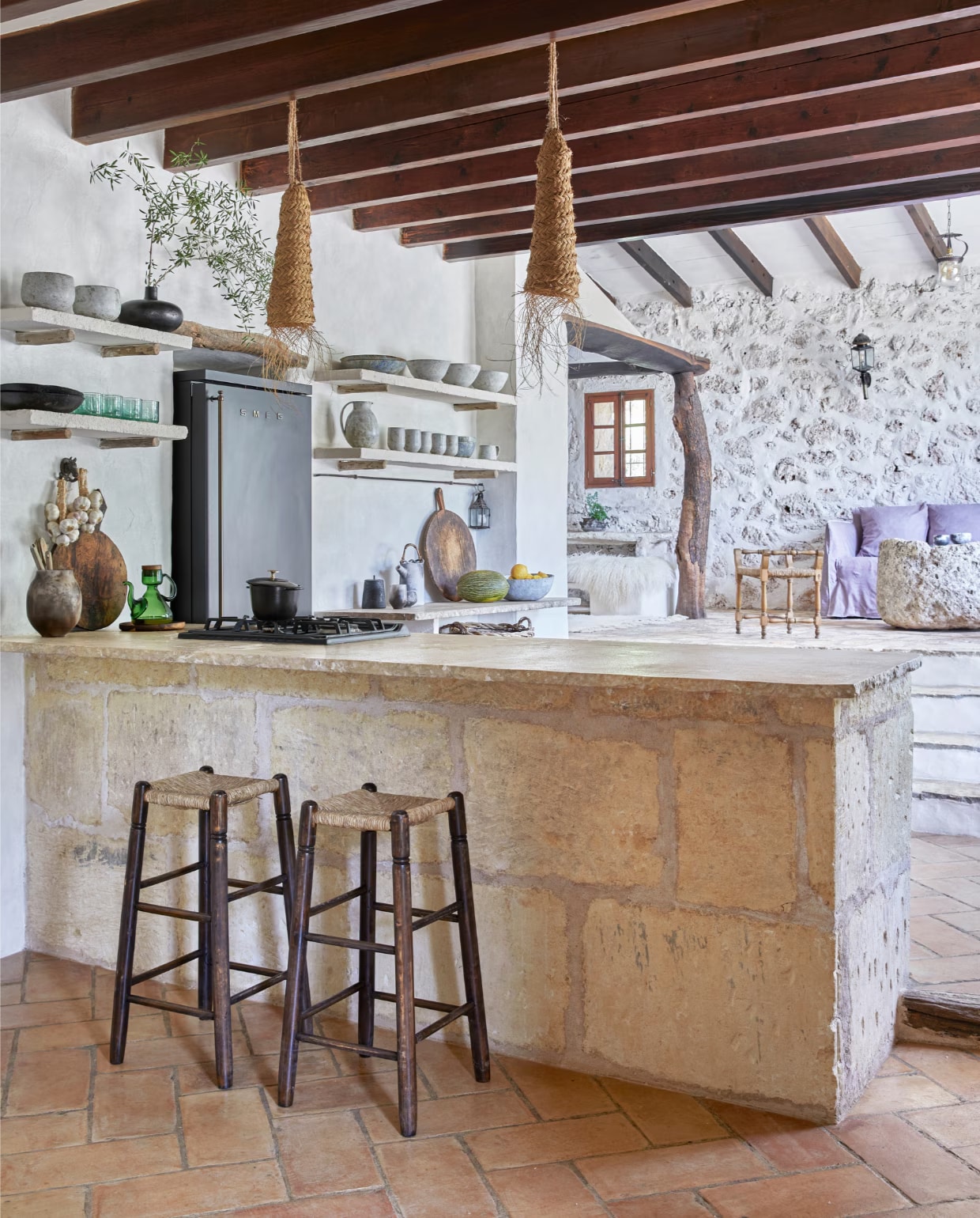 Hanglampen Can Garanya. Vintage barkrukken Charlotte Perriand. Koelkast Smeg. Het serviesgoed is van hun eigen bedrijf Terra Coll Home. Bank en poef Gervasoni. Salontafel zelfgemaakt van een oude steen. Stoel stond in het huis.
 vtwonen special binnenkijken 06-2023 | productie Bureaux/Living Inside | fotografie Greg Cox