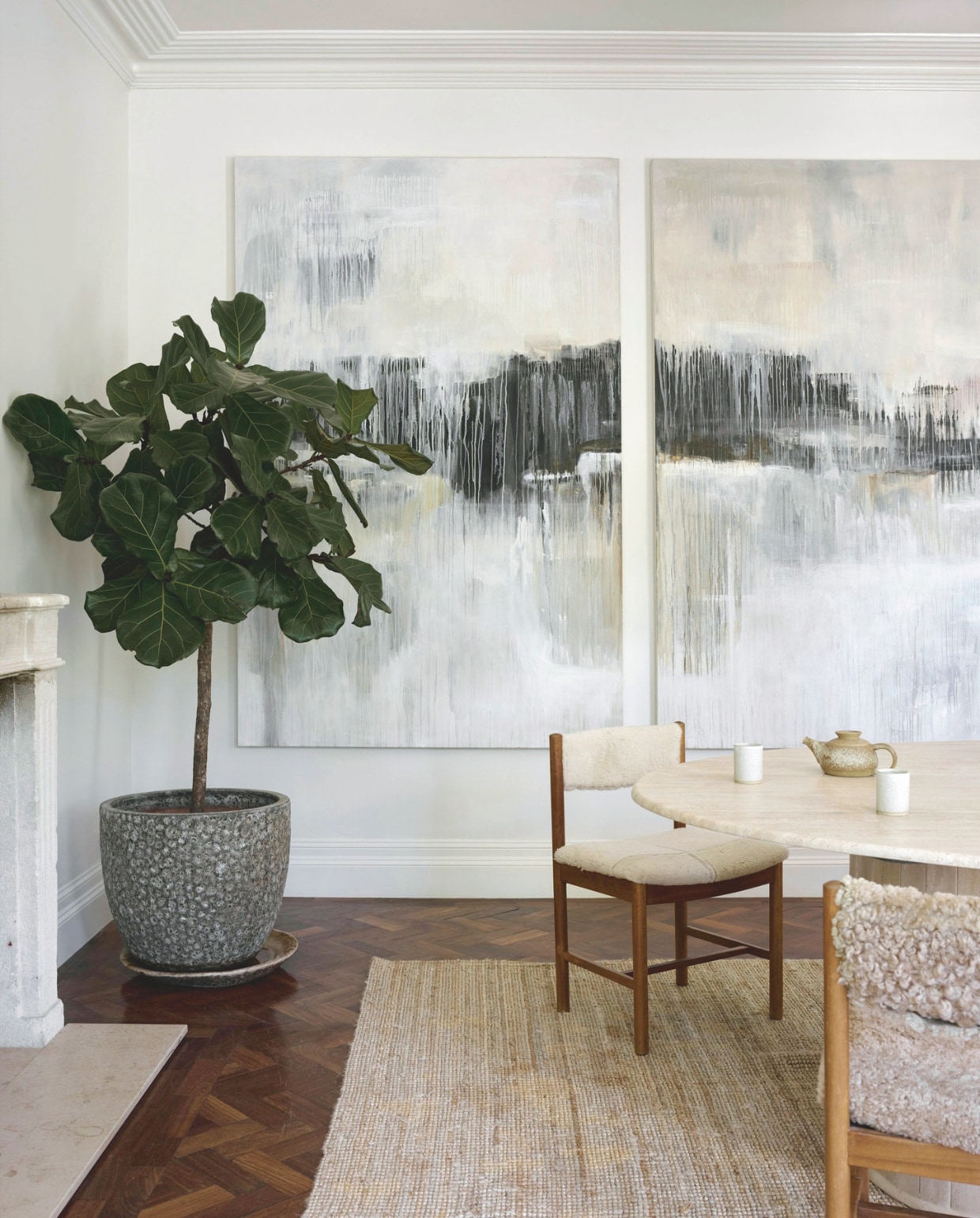 Vintage Deense stoelen bekleed met hergebruikte schapenvacht. Seventies Italiaanse tafel van travertin. Schilderij Oliver Hilton. Muurverf Linen Wash van Little Greene. vtwonen Landelijk 01-2026 | styling Ali Heath | fotografie Michael Sinclair