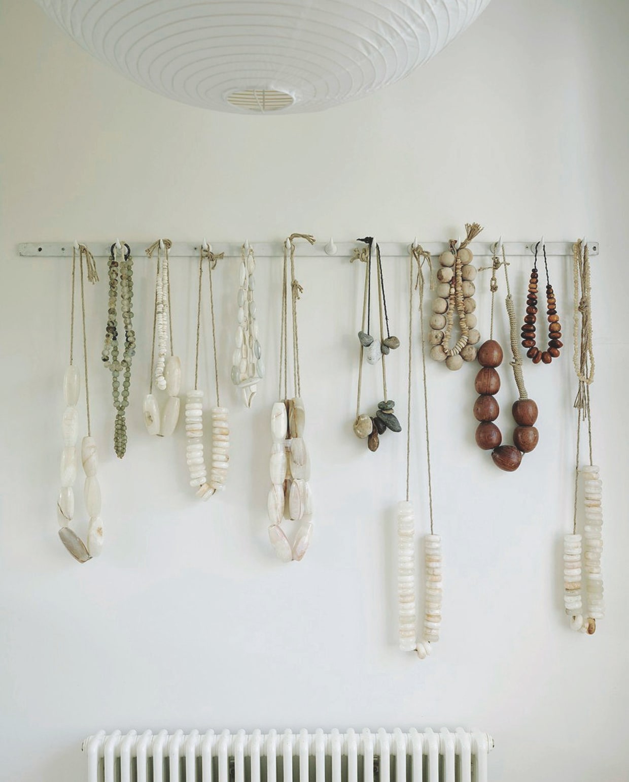 De collectie onyx-slingers en vintage houten kettingen fungeert als wanddecoratie. vtwonen Landelijk 01-2026 | styling Ali Heath | fotografie Michael Sinclair