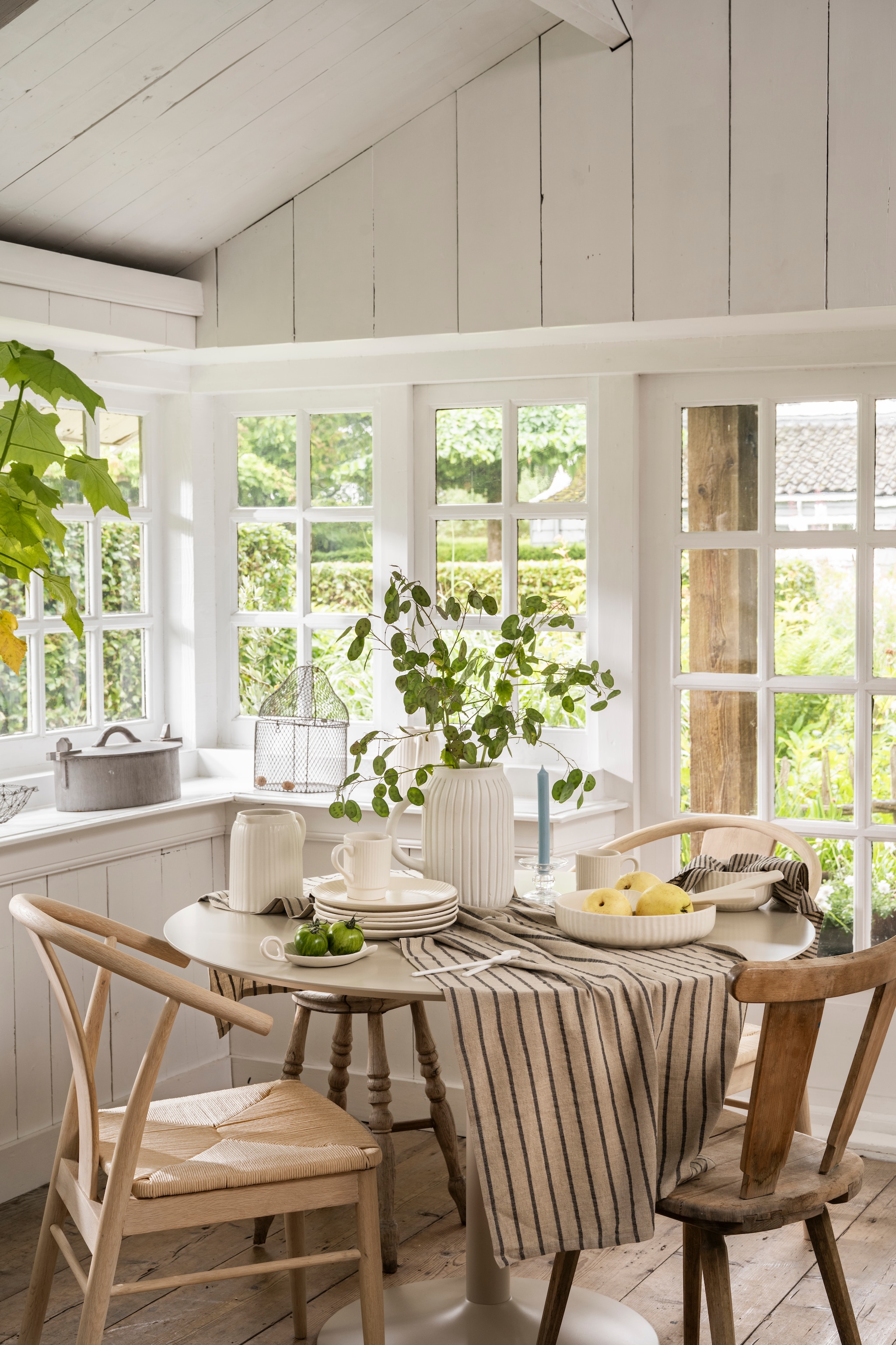 vtwonen vaas, terracotta, gebroken wit, 13x26 cm (Øxh) € 89,95, vtwonen karaf met oor, keramiek, gebroken wit € 29,95, vtwonen lepels wit, porselein, in diverse formaten, set van 6, vanaf € 19,95, vtwonen lepelhouder met oor, keramiek, 19,5x13x4,5 cm (lxdxh) € 14,95, vtwonen bord, keramiek, gebroken wit, 24 cm (Ø), set van 2 € 34,95. vtwonen mok met oor, keramiek, gebroken wit, set van 4 € 29,95, vtwonen slabestek, keramiek, gebroken wit, 24 cm en 30,5 cm (Ø), set van 2 € 19,95, vtwonen kom, keramiek, gebroken wit, 26x6 cm (Øxh) € 49,95M.m.v. fonq.nl (eettafel, lichtbruine eetkamerstoelen), shop.vtwonen.nl (vtwonen kandelaar). Overig privébezit. vtwonen 04-2026 | styling Sanne Ketelaar | fotografie Stan Koolen