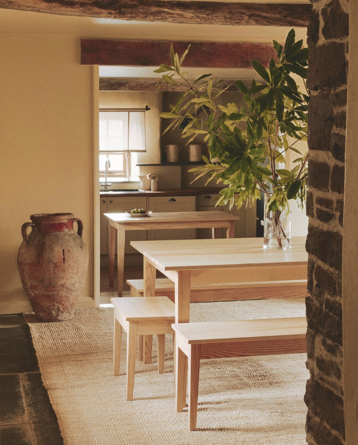 Eettafel, banken, kruk en werkeiland Wood|Edit. Vloerkleed Ikea. Grote pot Mangan Antiques. Muurkleur Cord van Farrow & Ball. vtwonen Landelijk 01-2026 | styling Ali Heath | fotografie Michael Sinclair