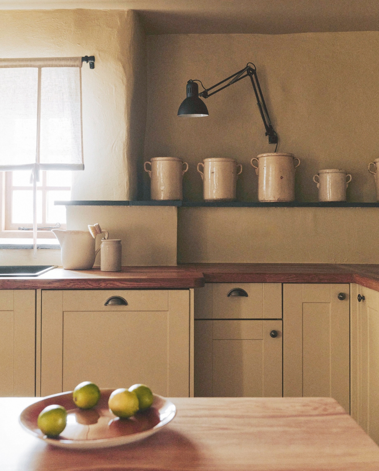 De crèmekleurige potten kocht Maria bij een lokale antiquair. Lamp Anglepoise. De keuken zat al in het huis. vtwonen Landelijk 01-2026 | styling Ali Heath | fotografie Michael Sinclair
