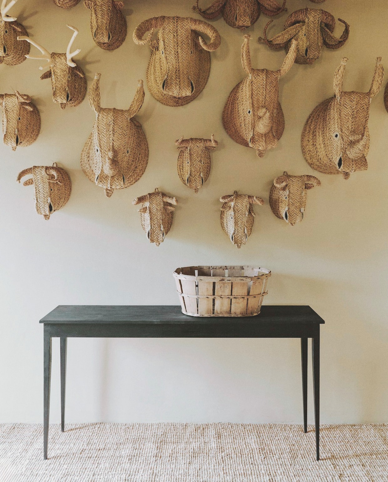 Dierenhoofden en zwart bankje Wood|Edit. Vloerkleed Ikea. Soortgelijke mand Loods 5. vtwonen Landelijk 01-2026 | styling Ali Heath | fotografie Michael Sinclair