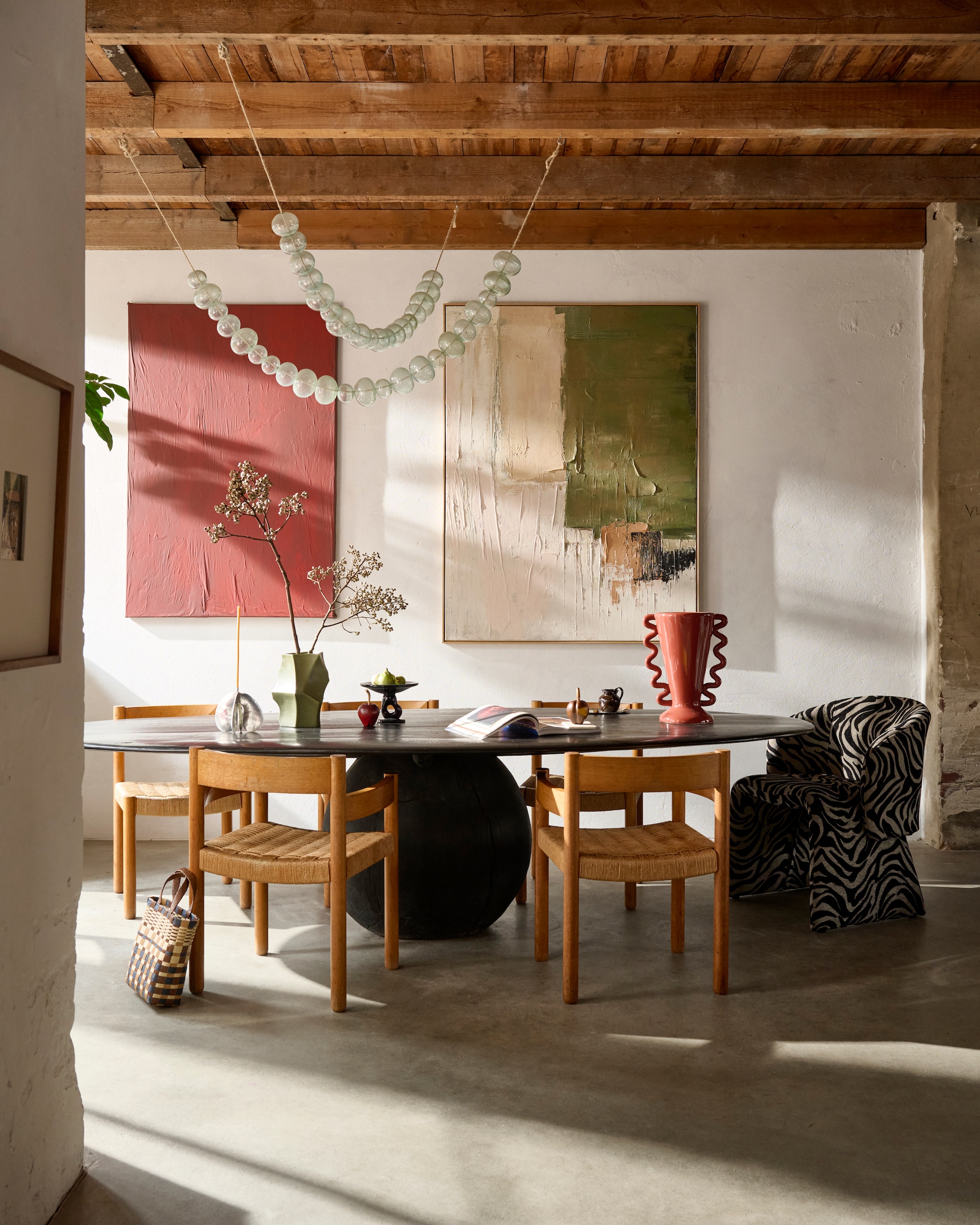 HKliving schilderij Nomad, canvas en hout, multicolour, 123x4x163 cm (bxdxh) € 695,- (hkliving.com). Urban Nature Culture fotolijst Ida, hout en glas, naturel € 79,99 (shop.vtwonen.nl). Hubert Crijns eettafel L’Ovale No.01, zwart, 240 tot 280 cm (l), prijs op aanvraag (hubertcrijns.com). Bregje Sliepenbeek kandelaar Phaedra, chroom€ 220,- (bregjesliepenbeek.com). Ferm Living vaas geometrisch, keramiek, legergroen € 80,-, glazen schaal op voet, glas, bruin € 152,- (fermliving.com). Loods 5 stoel Gigi, print € 295,- (loods5.nl). Karwei vaas, aardewerk, bruin € 51,99 (karwei.nl). Zara Home kan met reliëfmotief, aardewerk, bruin€ 9,99, tas, gevlochten vezel, meerkleurig/bruin € 15,99(zarahome.com). Overig privébezit. vtwonen 04-2026 | Styling Sanne Ketelaar | foto Sjoerd Eickmans