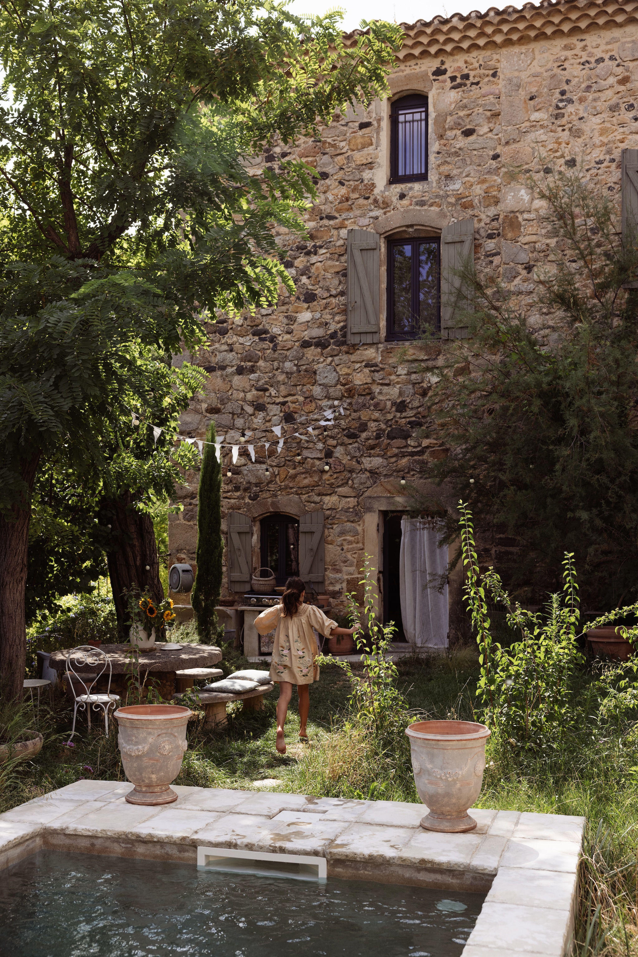 Zwembad zelf aangelegd. Anduze potten en bistrostoelen brocante. Verf luiken en deuren Kaki 7 van Dulux Valentine.
