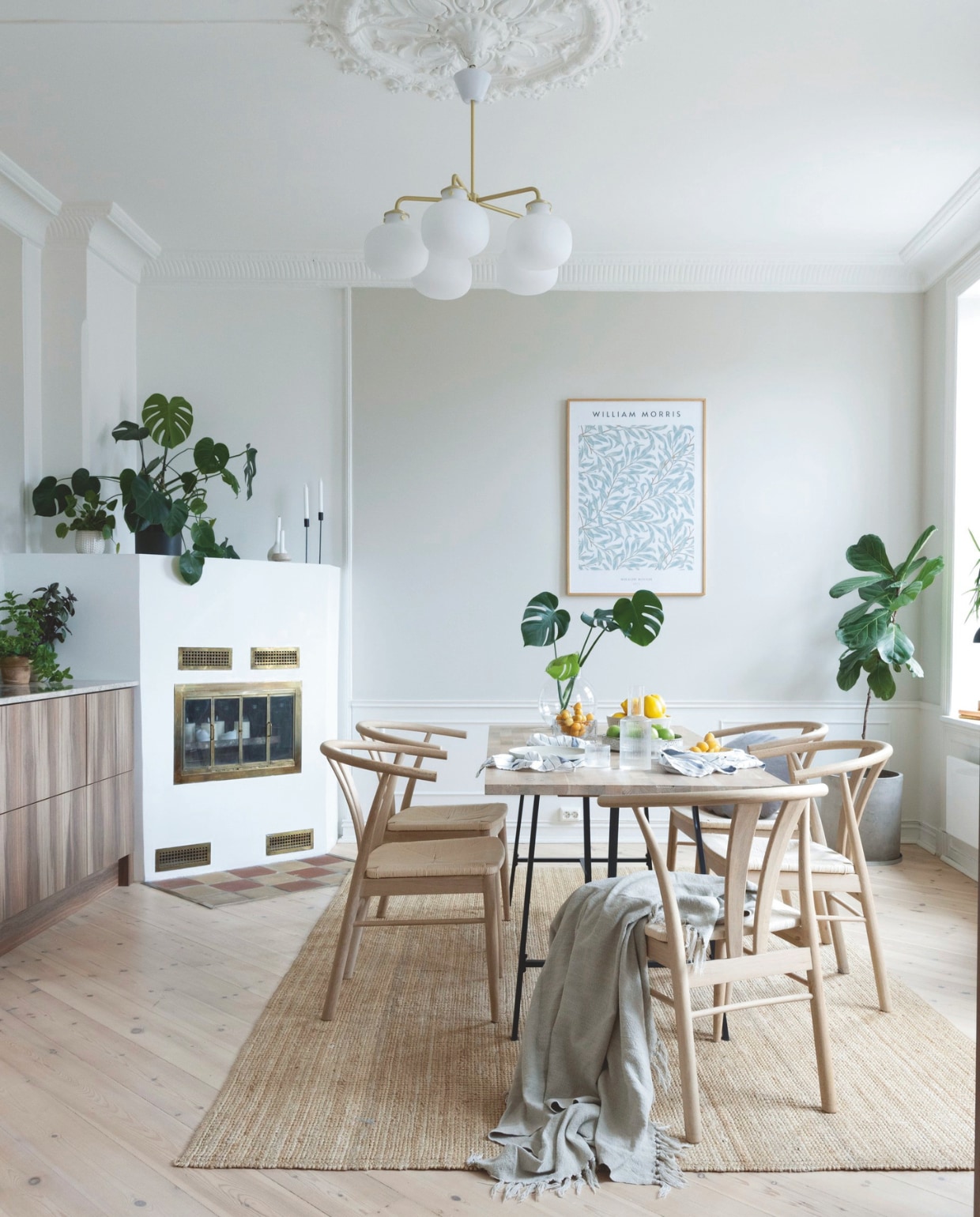 Eettafel zelf gemaakt. Stoelen van Møbelringen gekocht op tweedehandsplatform Tise, een alternatief is de CH24 Wishbone chair van Hans Wegner voor Carl Hansen. Print Desenio. Hanglamp Raito van Nordlux. Vloerkleed Strög van Ikea. De haard is origineel.
 vtwonen 01-2026 | styling Mari K. Olsen | fotografie Filippa Tredal | productie House of Pictures