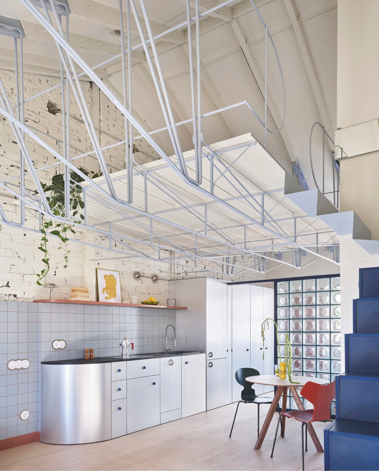 De keuken is op maat ontworpen voor de ruimte.  Tafel Cp20 van Hay. Stoelen Ant van Fritz Hansen. Vaas op de tafel Alvar Aalto. Allemaal via Espacio Betty. Op de vloer vinyl van QuickStep. vtwonen 01-2026 | fotografie Germán Sáiz