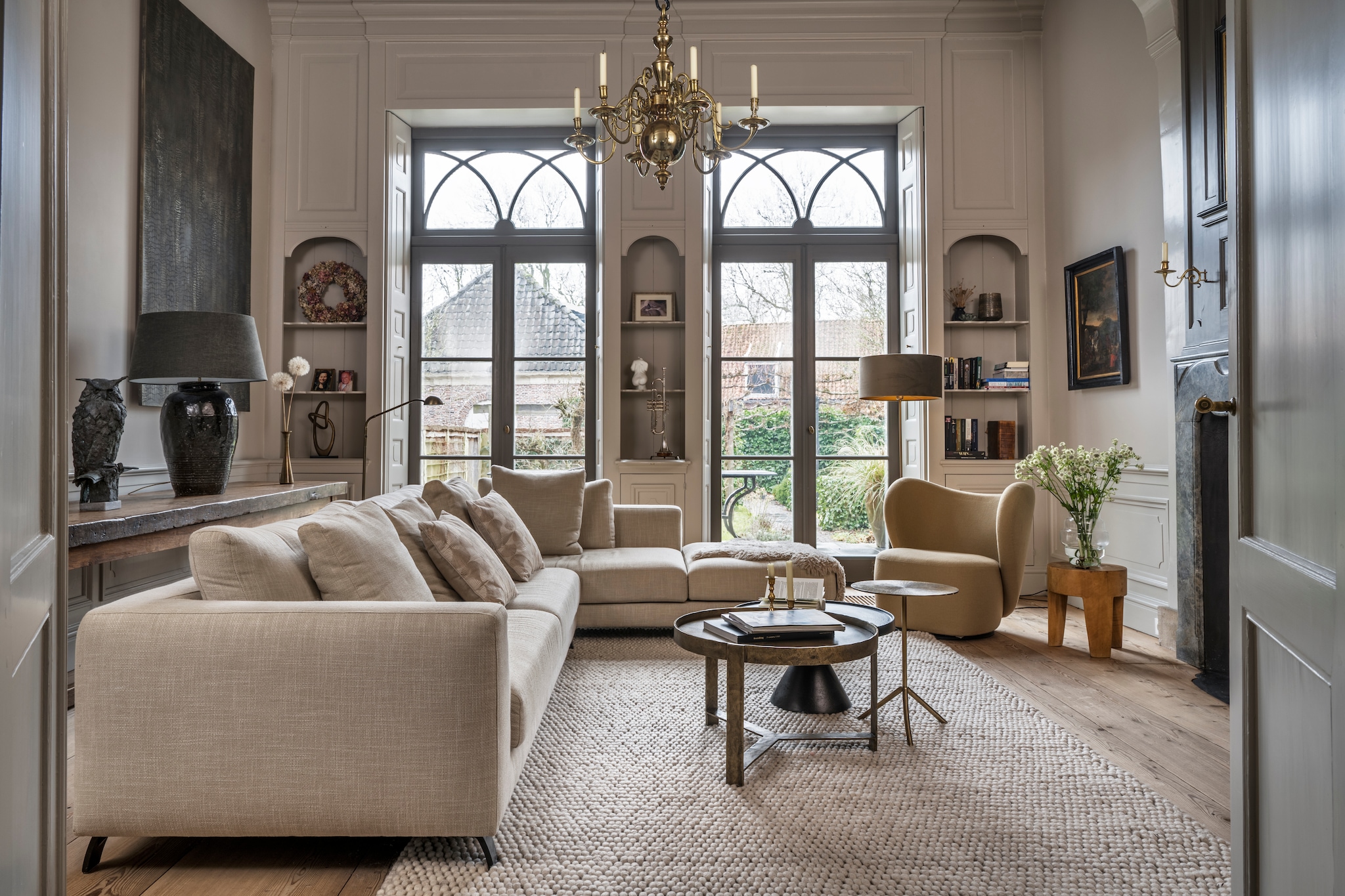 Bank en fauteuil Eijerkamp. Kussens Hinck. Schapenvacht Texelse Producten. Tafels en kruiklamp met kap Het Kabinet. Kruk Polspotten. Vloerlamp Licht Plaza. Trompet Antoine Courtois. Vloerkleed Peas van Hay. Sidetable gemaakt door vader van Cor. Bronzen vaas rommelmarkt. Panelen aan de muur Jb Interior Design. Kunstwerk aan de muur gekocht op een veiling. Krans zelfgemaakt met hortensia’s uit eigen tuin. Beeld Lifestyle. Beeld blote dame zelfgemaakt. Vloer onbehandelde Lariks kop- en staartvloer Leguit en Roos. Muurkleur Rolling Fog van Little Greene. vtwonen Landelijk 04-2026 | styling Marianne Luning | fotografie Stan Koolen