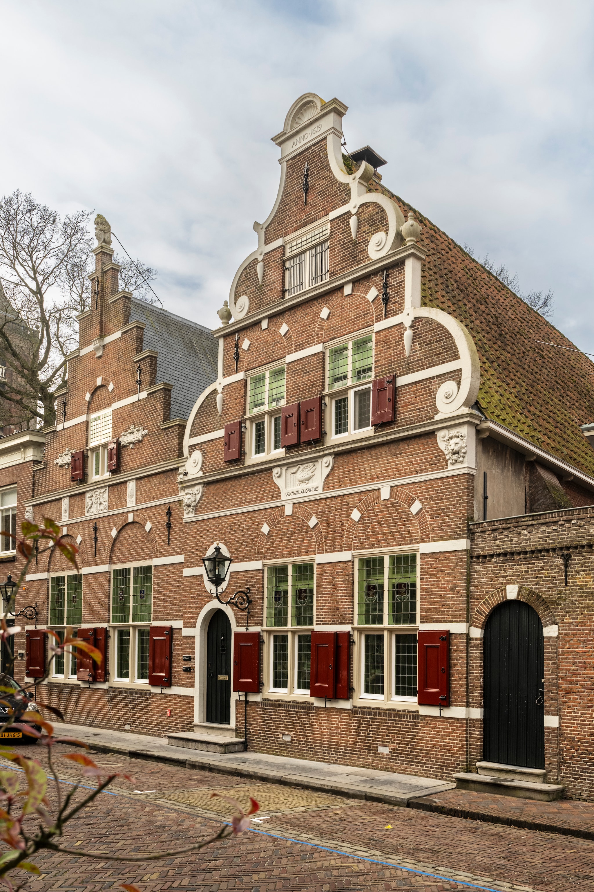 Het Rijksmonument met de gedeelde voordeur in het midden, links het huis van de familie Roos senior en rechts dat van de familie Roos junior.