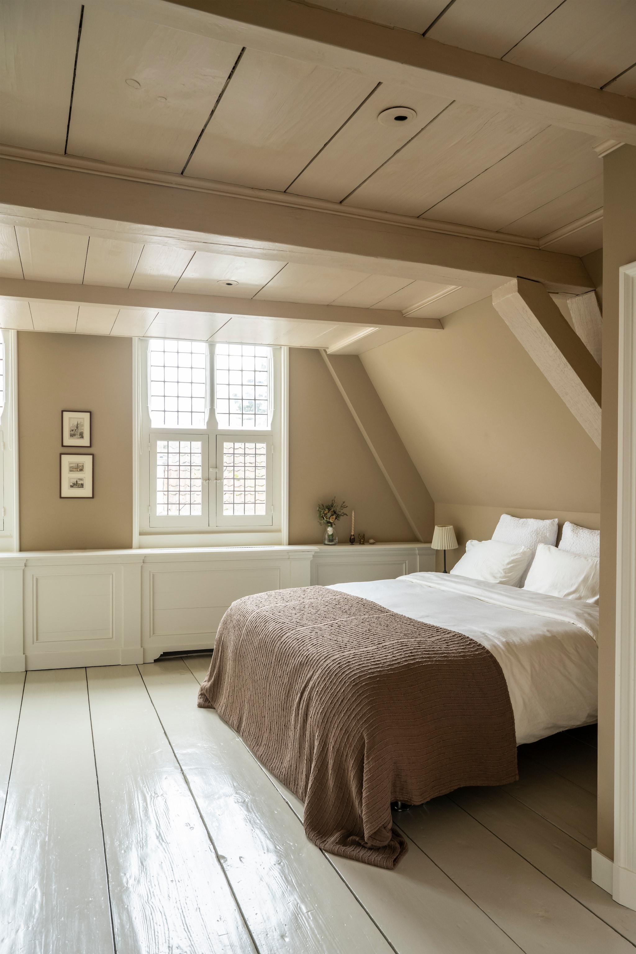 Beddengoed Zara Home. Sprei Westwing. Bruidsboeket Bloematelier Roos. Kandelaar dennenappel Twin Arts Lifestyle. Lamp Ikea. Boeddha gekregen. Muurkleur Oxford Stone en vloerkleur Cornforth White van Farrow & Ball. vtwonen Landelijk 04-2026 | styling Marianne Luning | fotografie Stan Koolen