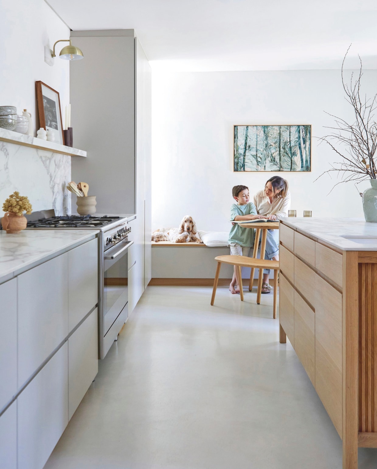 Keramieken pot met keukengerei Bernstein Pottery. Vaas rechts @home. Muurlamp Coricraft. Ronde tafel en banken Houtlander. Bankkussens zelfgemaakt door Janine. Kunstwerk Heidi Fourie. Gietvloer Maxicoatings. vtwonen 02-2026 | styling Sven Alberding | fotografie Greg Cox