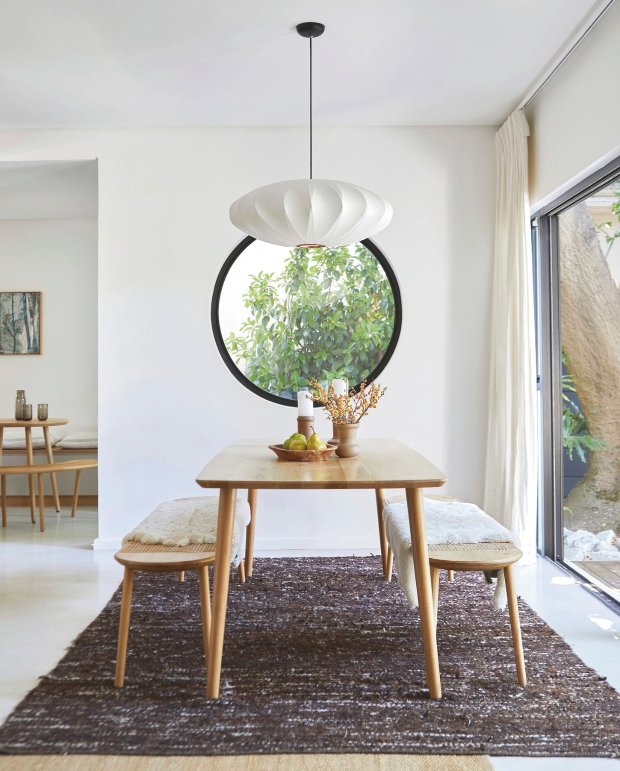 Tafel en banken Houtlander. Hanglamp Spazio Lighting. Wollen vloerkleed Weylandts. Kunstwerk Heidi Fourie. vtwonen 02-2026 | styling Sven Alberding | fotografie Greg Cox