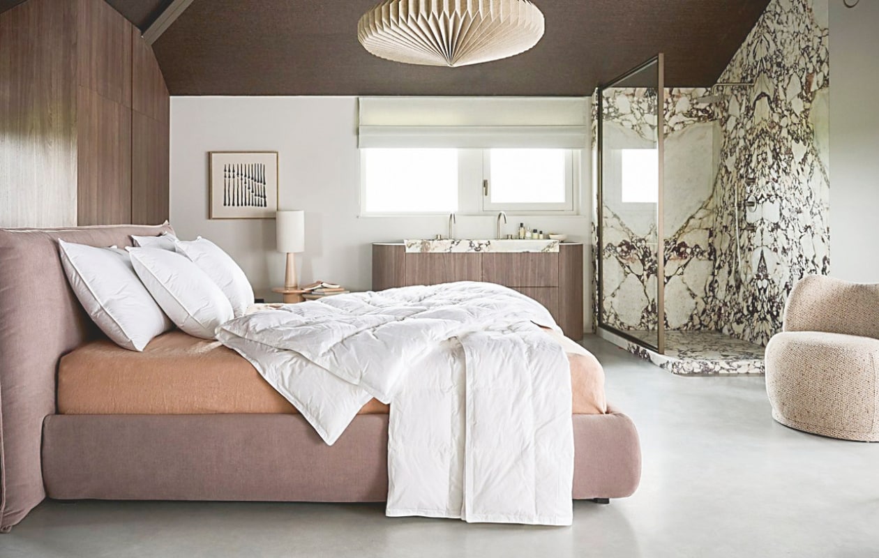 vtwonen dekbed Dixxius Green Royal, gerecycled dons, vanaf € 190,-, vtwonen vierseizoenendekbed Dixxius Green Royal, gerecycled dons, vanaf € 275,-, vtwonen hoofdkussen The sustainable one, gerecycled dons, vanaf € 79,95.M.m.v. loods5.nl (hanglamp, lampvoet matt nude, bijzettafel soft orange), hkliving.com (linnen lampenkap naturel, bijzettafel cream), zarahome.com (hoeslaken linnen/katoen). Overig privébezit. vtwonen 02-2026 | styling Kim van Rossenberg | fotografie Sjoerd Eickmans