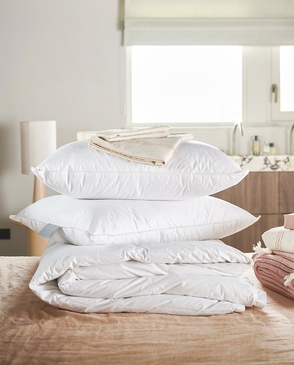 vtwonen dekbed Dixxius Green Royal, gerecycled dons, vanaf € 190,-, vtwonen hoofdkussen The sustainable one, gerecycled dons, vanaf € 79,95.M.m.v. loods5.nl (lampvoet, bijzettafel, sprei), hkliving.com (lampenkap), zarahome.com (linnen/katoenen hoeslaken, gestreepte kussenslopen, gestreept dekbedovetrek, roze satijnen hoeslaken). Overig privébezit. vtwonen 02-2026 | styling Kim van Rossenberg | fotografie Sjoerd Eickmans