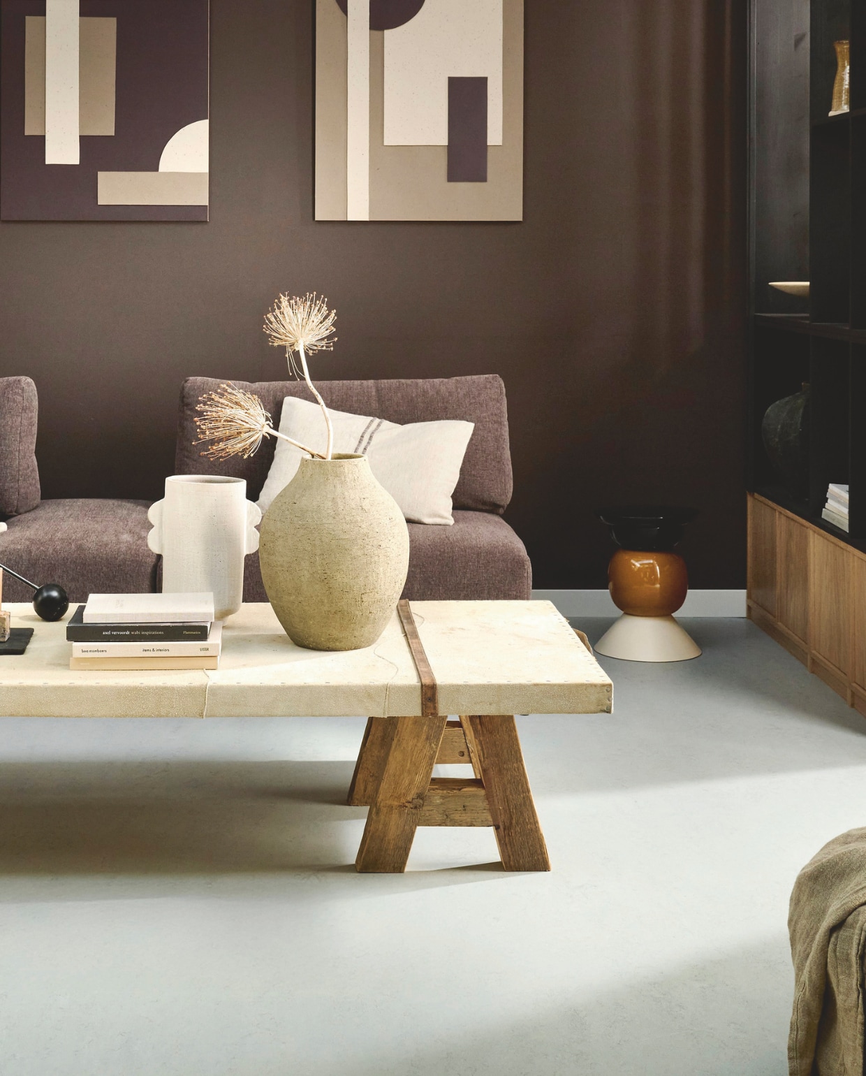 vtwonen Marmoleum Marble, water, 200 cm breed, per m² € 53,80.M.m.v. com-anders.nl (salontafel met schragen), zarahome.com (kruk, plaid en kussens), vtwonen.nl (bank Couple van vtwonen, houten onderkast Modulair van vtwonen). Overig privébezit. vtwonen 02-2026 | styling Kim van Rossenberg | fotografie Sjoerd Eickmans