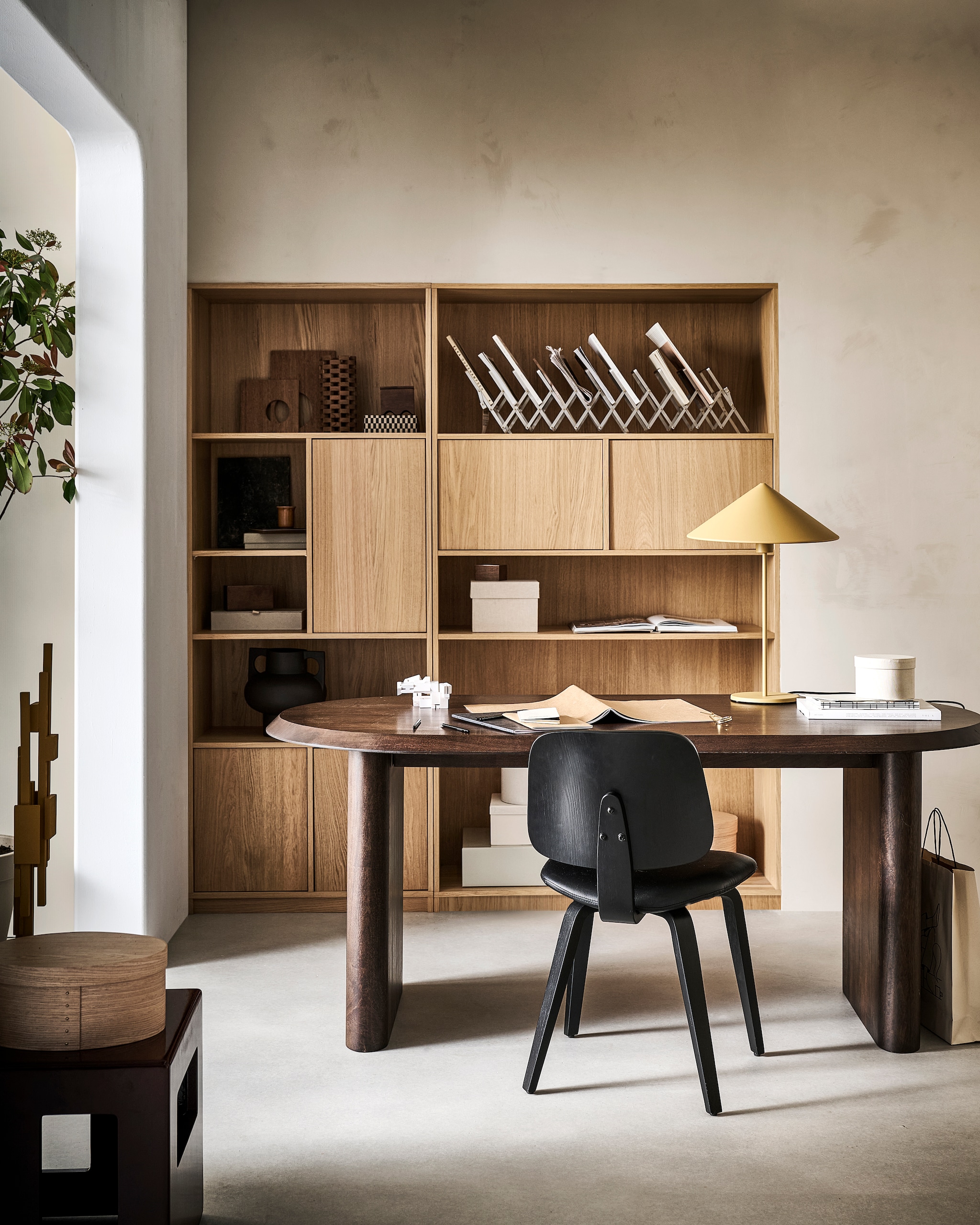 Mangohouten eettafel Elips in Walnoot, 180x90x75 cm (lxbxh) € 1299,-, ook verkrijgbaar in 240x90x75 cm € 1599,-. Stoel Classic in Zwart, leerlook en walnoothout, 50x48x81 cm (bxdxh) € 149,-, ook verkrijgbaar in bruin/zwart. Eikenfineer modulaire kast, zoals hier samengesteld: links bovenkast Modulair, 77x40x199 cm (bxdxh) € 749,- en rechts bovenkast Modulair, 110x40x199 cm (bxdxh) € 779,-, verkrijgbaar in diverse formaten en onderdelen. M.m.v. vtwonen.nl/shop (tafellamp van HKliving), hay.nl (doos), zarahome.com (tijdschriftenhouder, ronde doos, doosje met deksel), hm.com (doos met geschulpte rand, vaas). Overig privébezit. vtwonen 07-2024 | styling Sanne Ketelaar | fotografie Sjoerd Eickmans