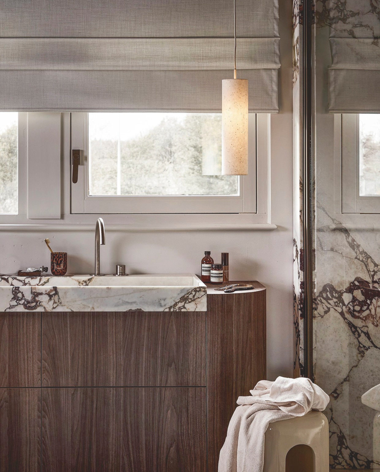 vtwonen hanglamp Paper Tube, papier, 11x40 cm (Øxh) € 49,99.M.m.v. skins.nl (flesjes Aesop). Overig privébezit. vtwonen 02-2026 | styling Marlies Does | fotografie Peggy Janssen